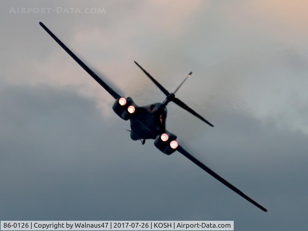 86-0126, 1986 Rockwell B-1B Lancer C/N 86, Rear view of USAF B-1B AF 86-0126 Cn 86 starting a Dusk ‘Afterburner Vapour Run’, with wings swept forward. Photo taken at the start of the Night Airshow, at Air Venture Oshkosh KOSH on 26Jul2017. Vapour is forming on the wings as the aircraft accelerated
