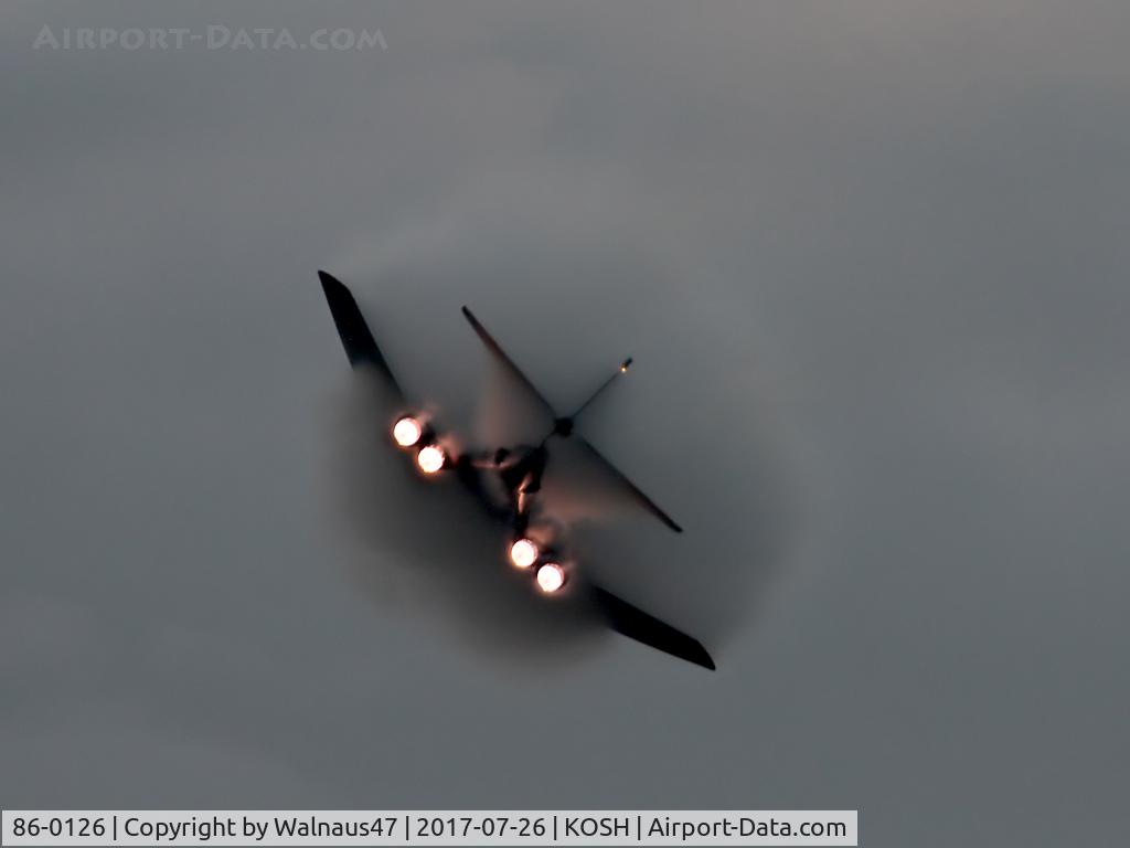 86-0126, 1986 Rockwell B-1B Lancer C/N 86, Low res Rear view of USAF B-1B AF 86-0126 Cn 86 starting a Dusk ‘Afterburner Vapour Run’, with wings swept back. Photo taken at the start of the Night Airshow, at Air Venture Oshkosh on 26Jul2017. Vapour envelops the B-1B as the aircraft touches Mach1.