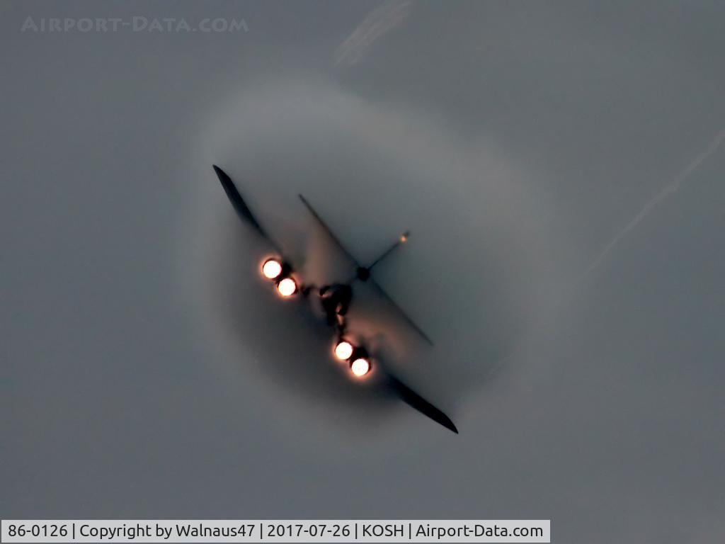 86-0126, 1986 Rockwell B-1B Lancer C/N 86, Low res Rear view of USAF B-1B AF 86-0126 Cn 86 starting a Dusk ‘Afterburner Vapour Run’, with wings swept back. Photo taken at the start of the Night Airshow, at Air Venture Oshkosh KOSH on 26Jul2017. Vapour envelops the B-1 as the aircraft touches Mach1