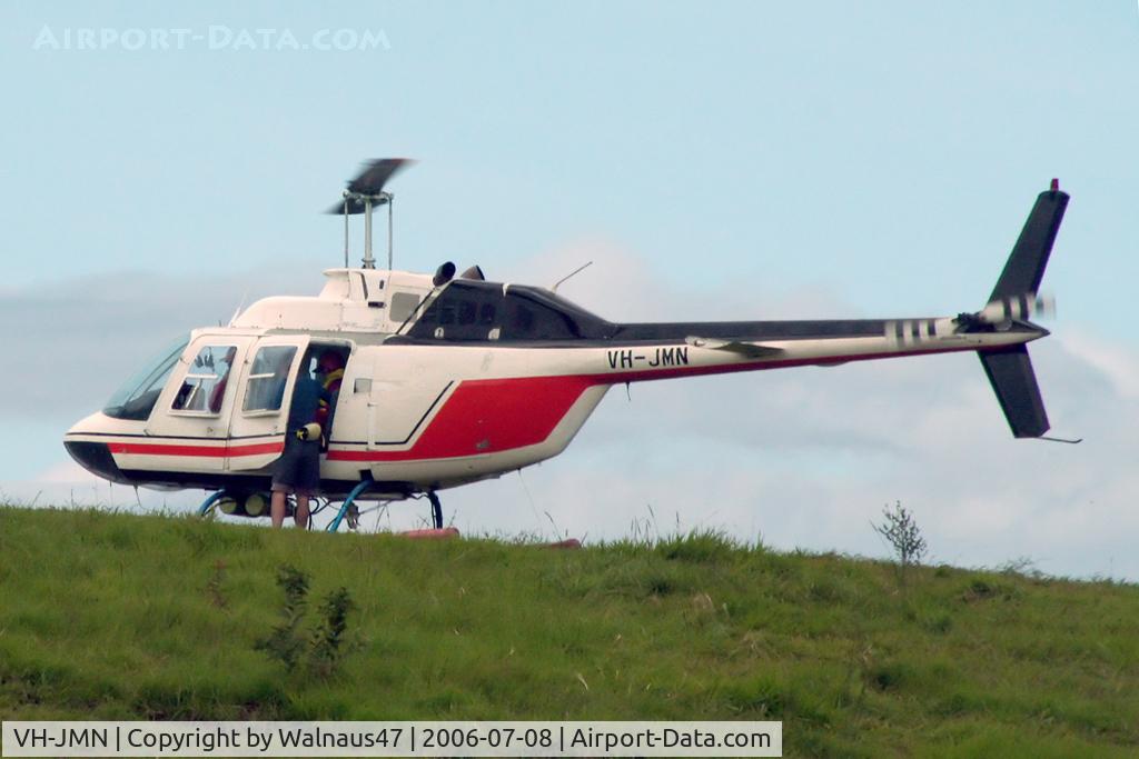 VH-JMN, 1974 Bell 206B JetRanger II C/N 1353, Port side view of Bell 206B JetRanger II VH-JMN Cn 1353 on a hillside near Cairns before departing to a pontoon on the Great Barrier Reef QLD on 08Jul2006. The helo is fitted with ‘pop-out floats’ for over-water operations.