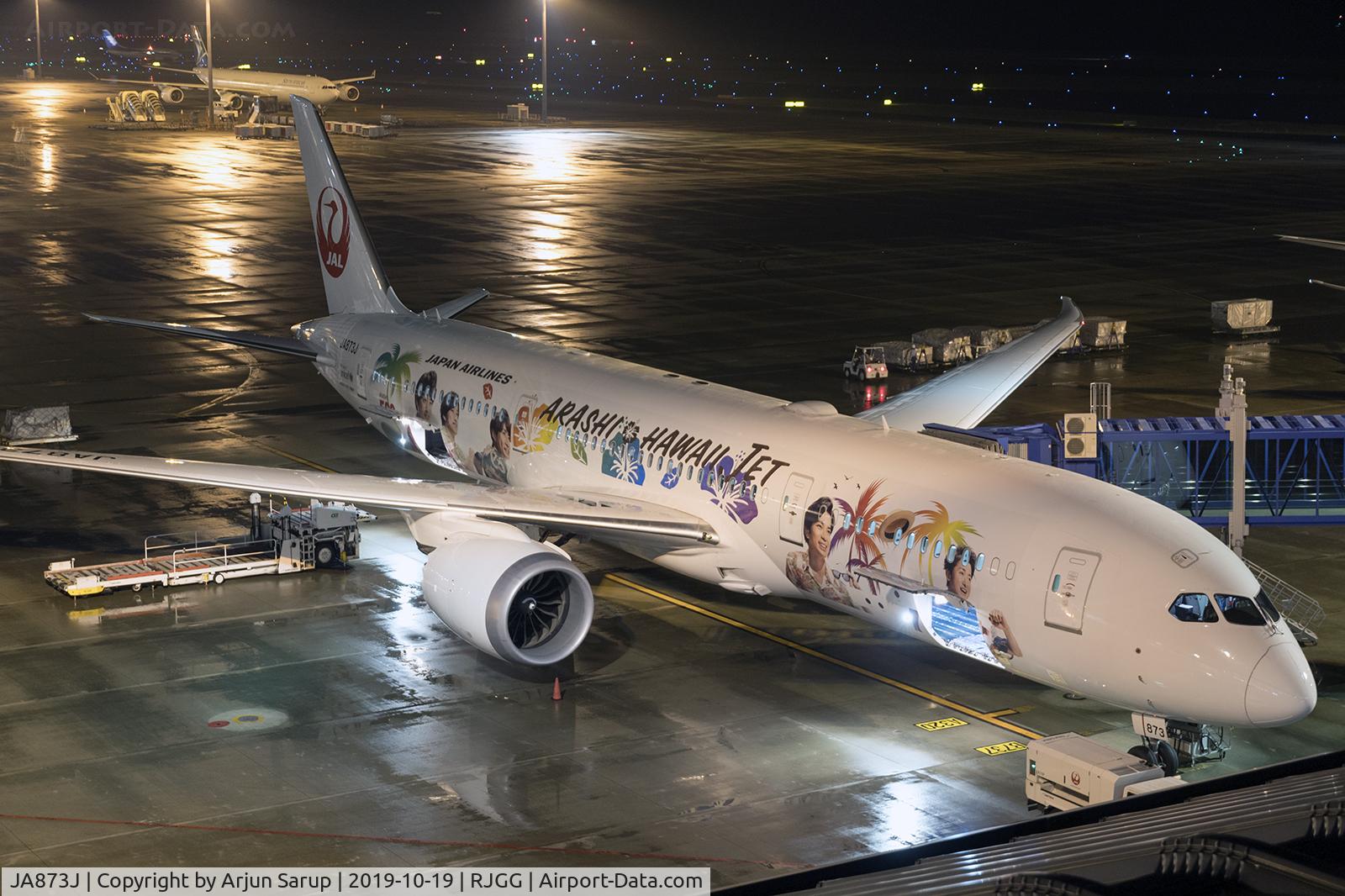JA873J, 2018 Boeing 787-9 Dreamliner C/N 34852, Named after a Japanese boy band, “Arashi Hawaii Jet” is at the gate at Chubu Centrair International Airport on a wet night.