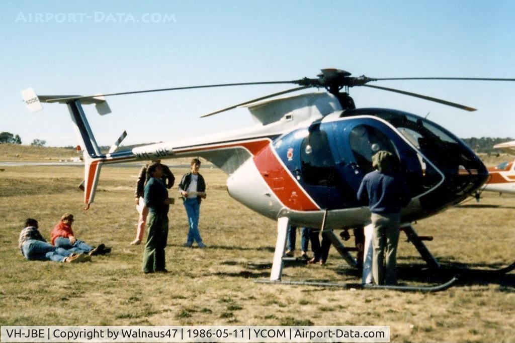 VH-JBE, Hughes 369E C/N 0148E, Hughes 369E VH-JBE Cn 0148E being inspected  on static display at Cooma Airport YCOM, during the 'Snow Opening' Airshow on 11May1986. The helo was previously USA Registered as N5229J, and was being operated for U.A.A. Films Limited in Sydney in Nov 1985.