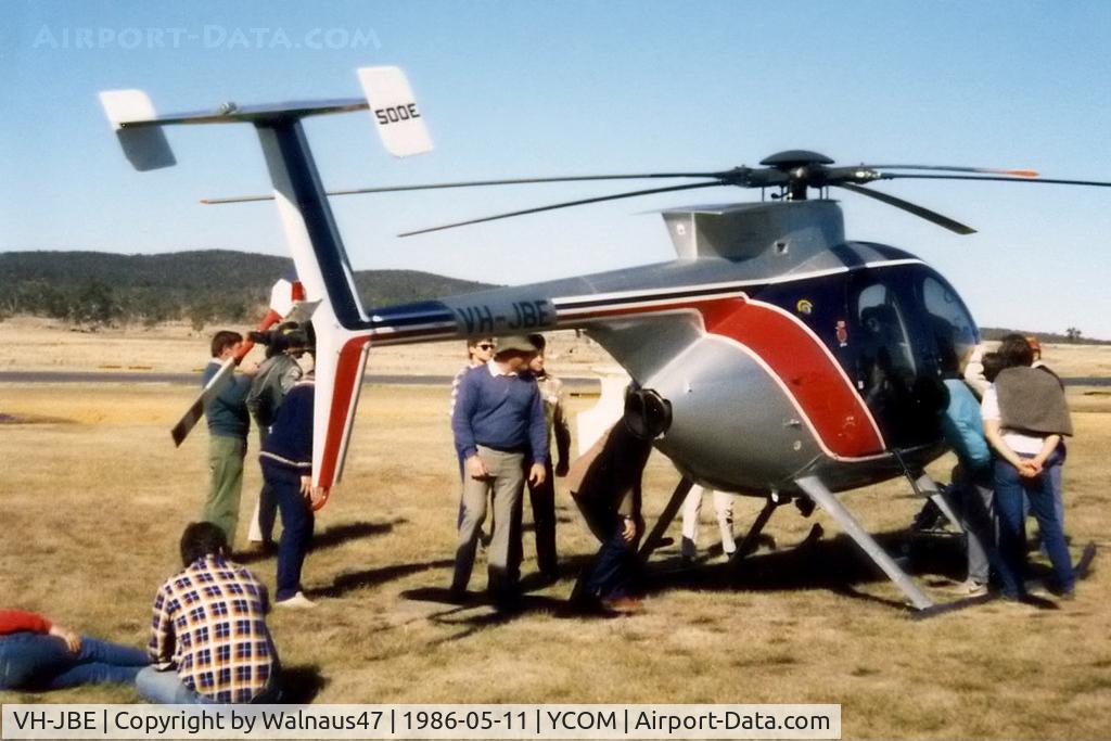 VH-JBE, Hughes 369E C/N 0148E, Hughes 369E VH-JBE Cn 0148E being inspected  on static display at Cooma Airport YCOM, during the 'Snow Opening' Airshow on 11May1986. The helo was previously USA Registered as N5229J, and was being operated for U.A.A. Films Limited in Sydney in Nov 1985.