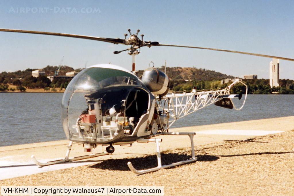 VH-KHM, 1967 Bell 47G-3B-1 Sioux C/N 6629, Heli-Muster Bell 47G-3B-1 helicopter VH-KHM Cn 6629  taken at Canberra’s Lake Burley Griffin in Mar 1991. (Russell Offices and the Carillon are visible at rear.) The helo was in town for Canberra Week activities