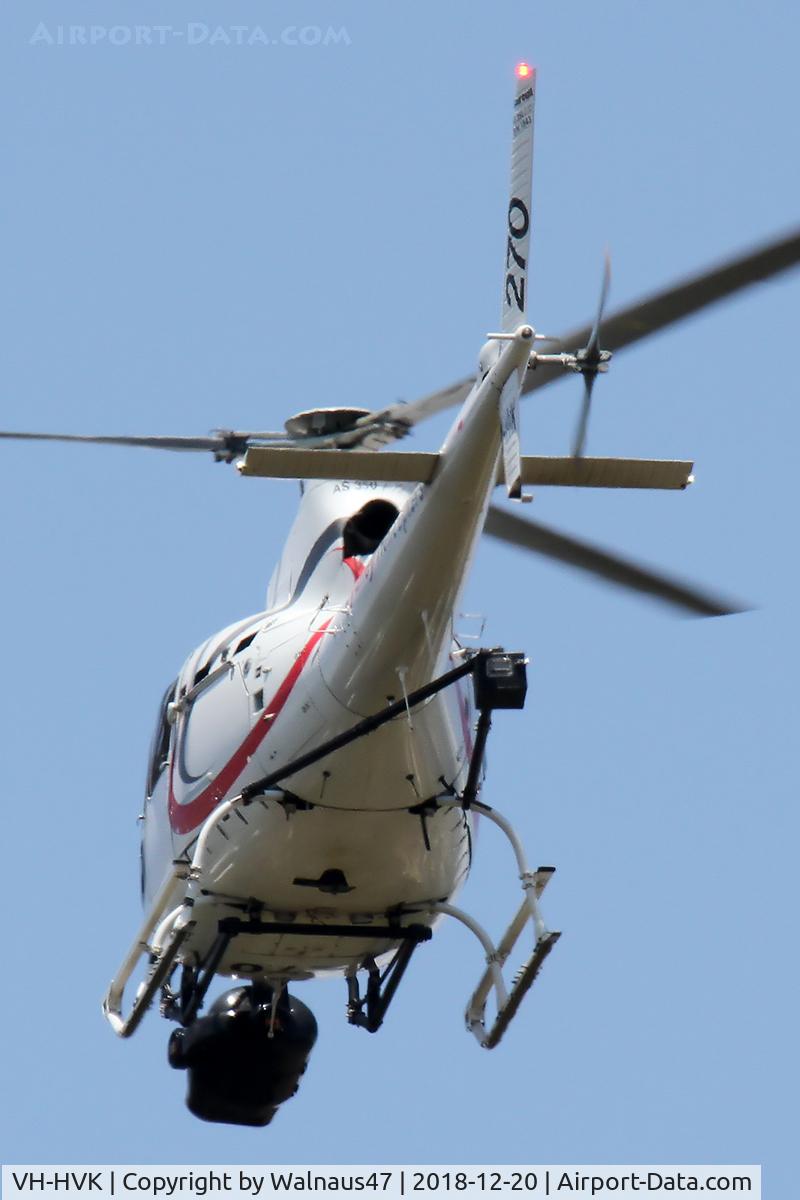 VH-HVK, 1985 Eurocopter AS-350B Ecureuil Ecureuil C/N 1843, Sydney Helicopters Aerospatiale AS 350B Ecureuil VH-HVK Cn 1843 Code 270 flying low over southern Canberra suburbs on 20Dec2018. The helo has a ‘Video Sensor ball’ mounted under the nose, and has a ‘counter-balance’  mounted on struts behind the cabin.
