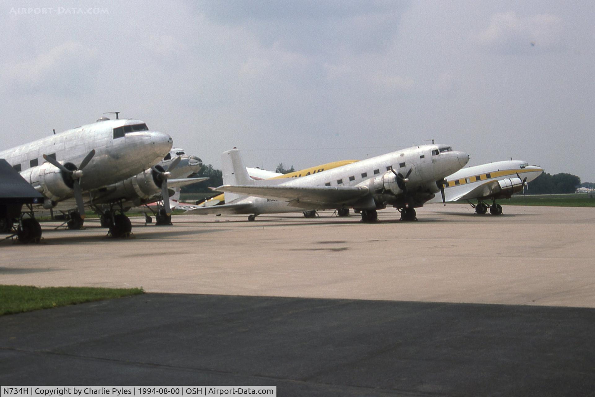 N734H, 1942 Douglas DC-3 (C-47-DL) C/N 4727, N734H is the yellow airplane in the background on this Basler Ramp in 1994. The yellow/black airplane behind it is N23SA,  the Polair Conroy Tri-Turbo-Three was a Douglas DC-3 fitted with three Pratt & Whitney Canada PT6A turbop