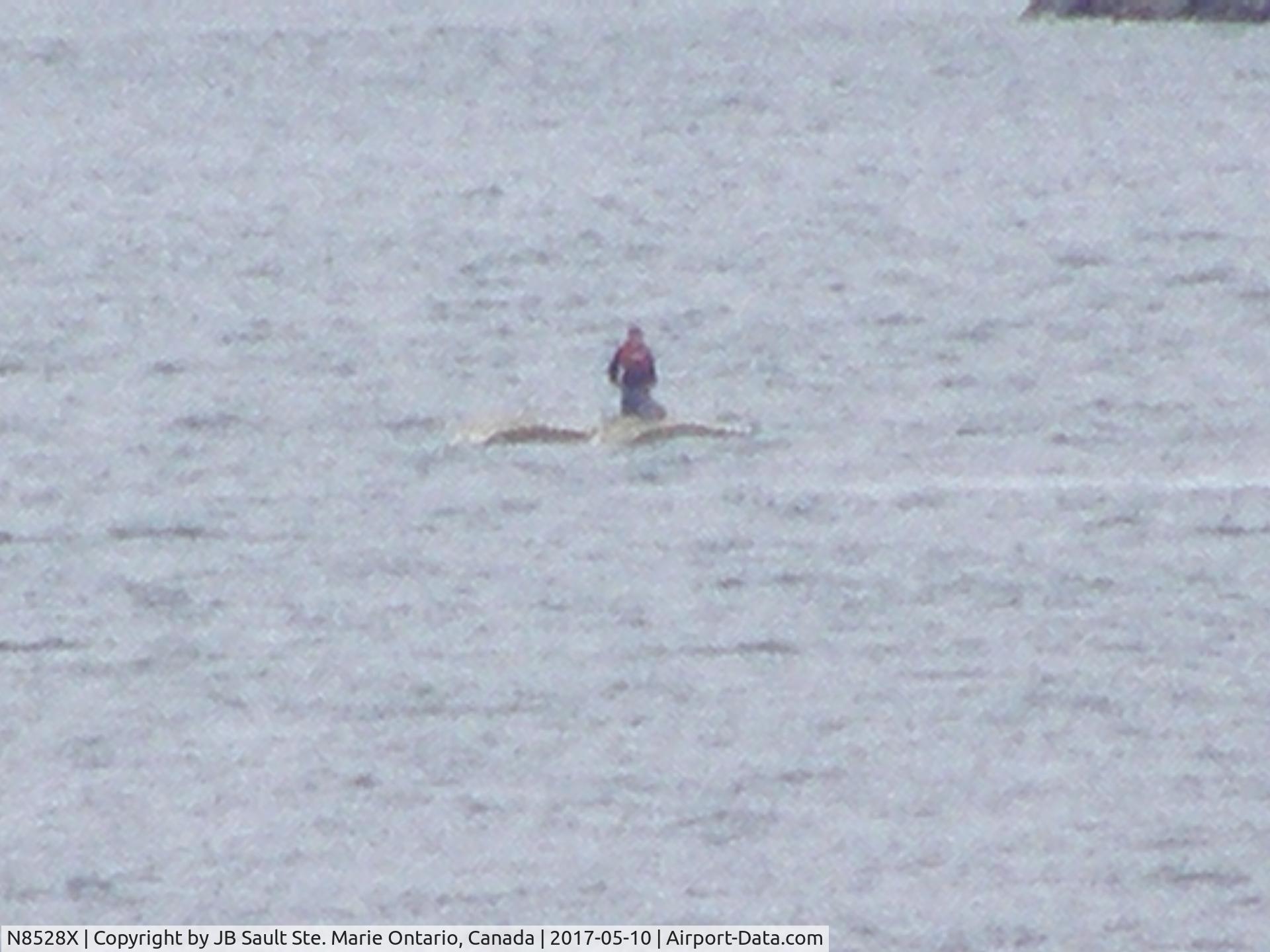 N8528X, 1962 Cessna P172D Skyhawk Powermatic C/N P17257128, A photo of N8528X after flipping over in the St. Mary's river on May 10th 2017 while attempting to land. Pilot standing on overturned plane's floats waiting for rescue.