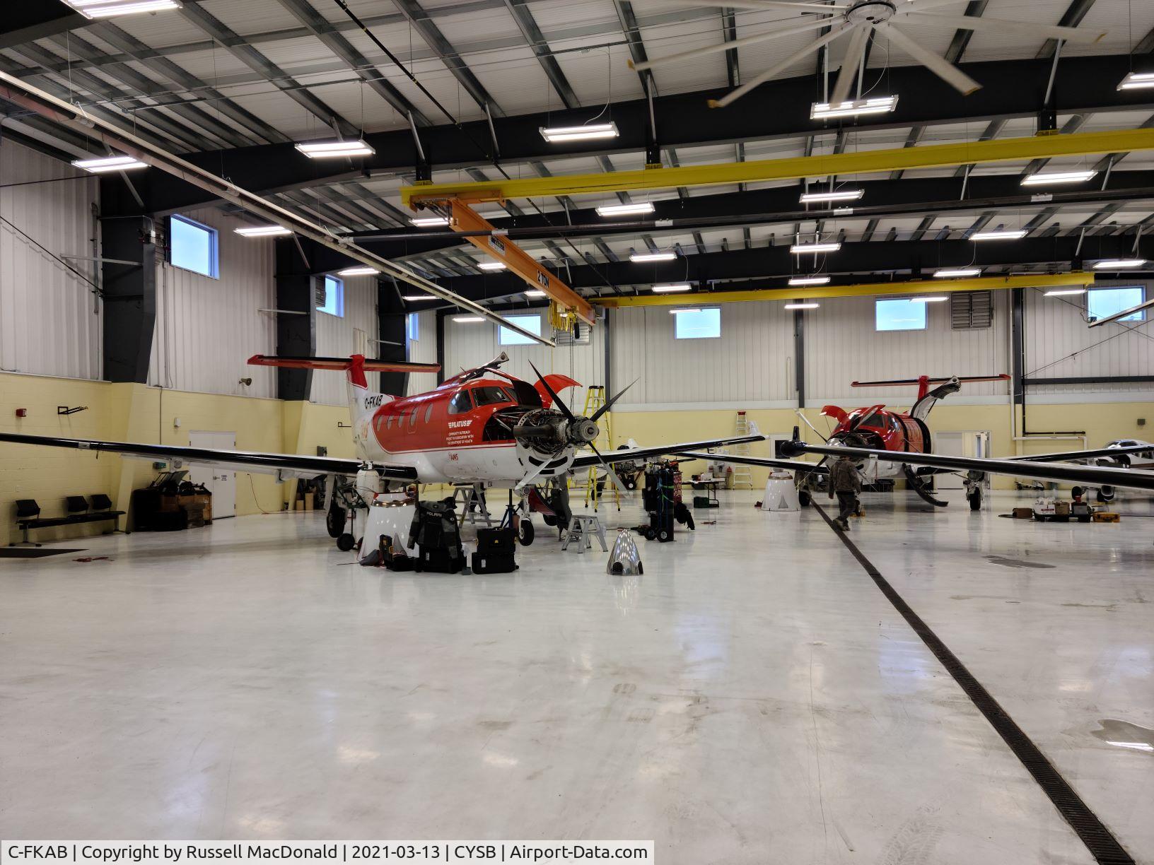 C-FKAB, 2005 Pilatus PC-12/45 C/N 634, just arrived (along with another PC-12 from ZA same source) in hangar at CYSB - undergoing maintenance and conversion to new owner