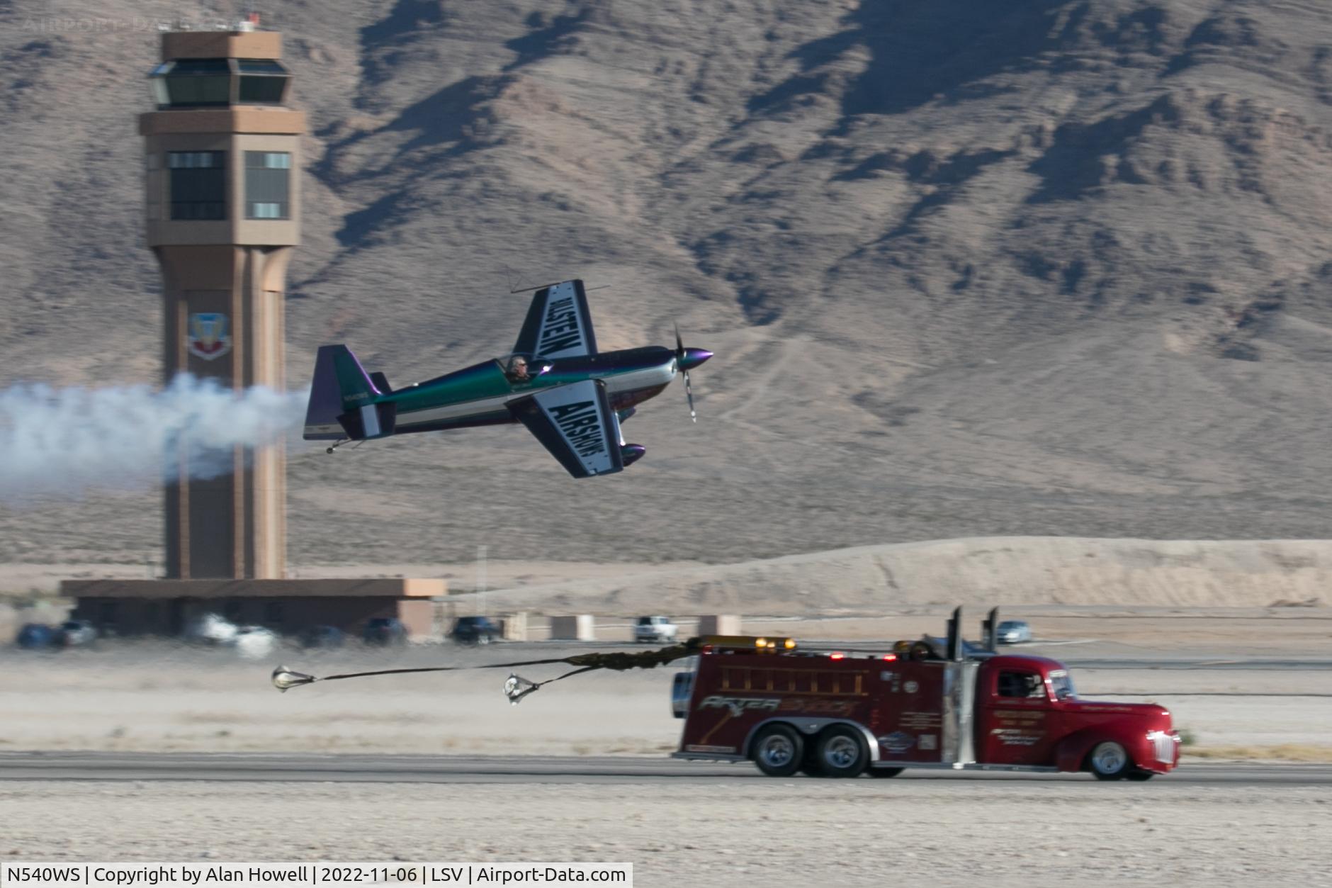 N540WS, 2002 Zivko Edge 540 C/N 0032, Bill Stein is passed by the jet powered fire truck Aftershock which has already started to deploy its brake 'chutes, at Aviation Nation 2022. Was Bill really trying to win...?