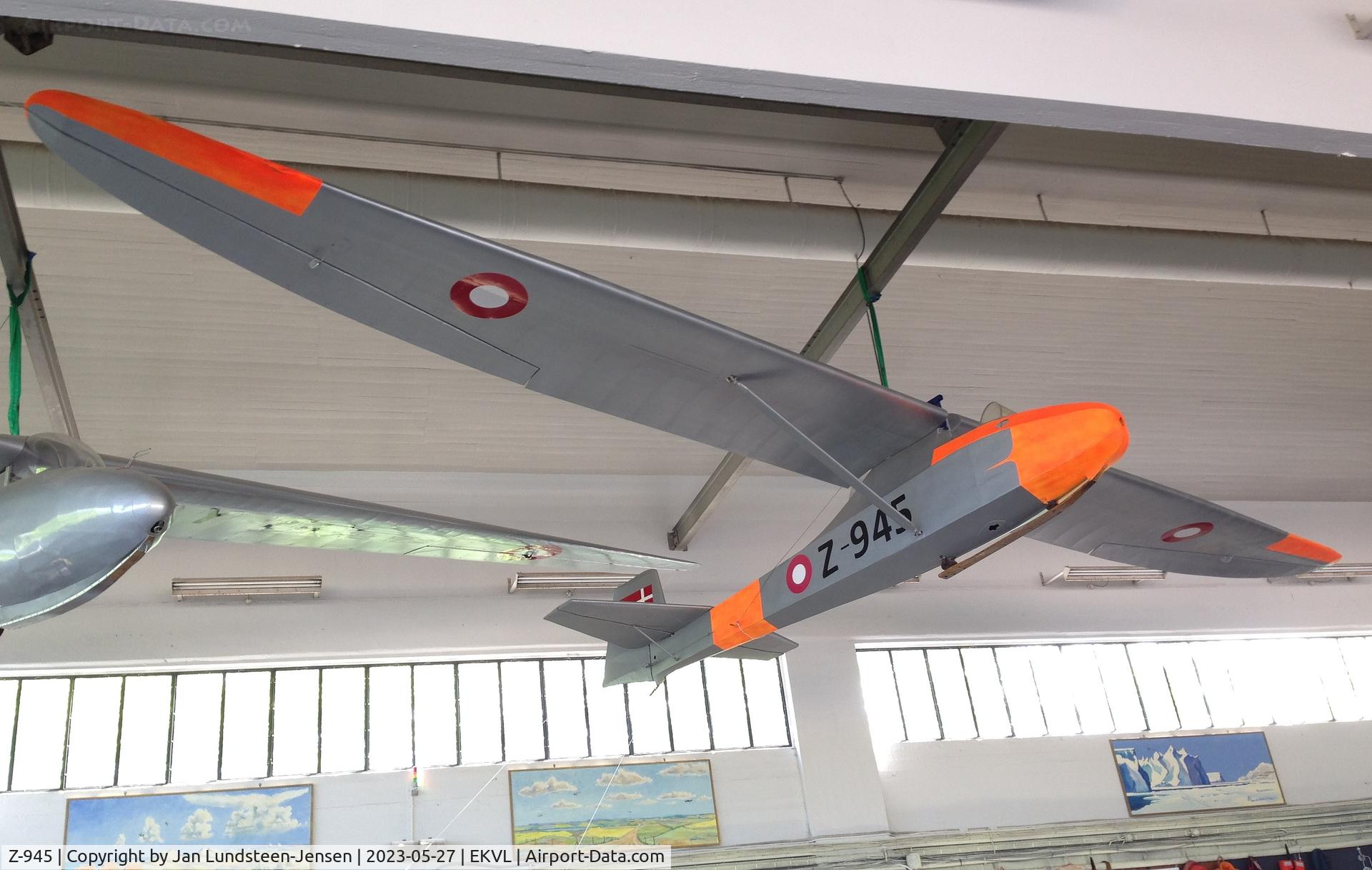 Z-945, 1949 Schneider Grunau Baby IIb C/N Unknown, Grunau Baby seen under the roof in Hangar 2 at Vaerloese, Denmark. Ex Royal Danish Air Force 94-945 and Z-945. Damaged at Aalborg Air Base in 1966 and withdrawn from use. Restored and painted in a 1960s Danish air force colour scheme.