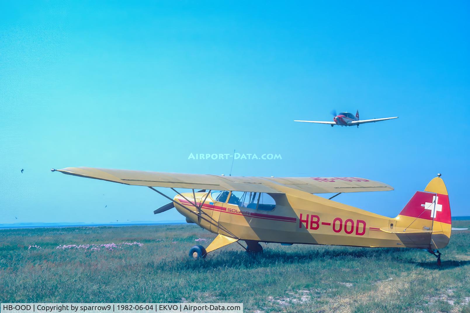 HB-OOD, 1946 Piper PA-12 Super Cruiser C/N 12-558, On the nice island of Vejro. Bellanca HB-DUN on a low pass. Scanned from a slide.