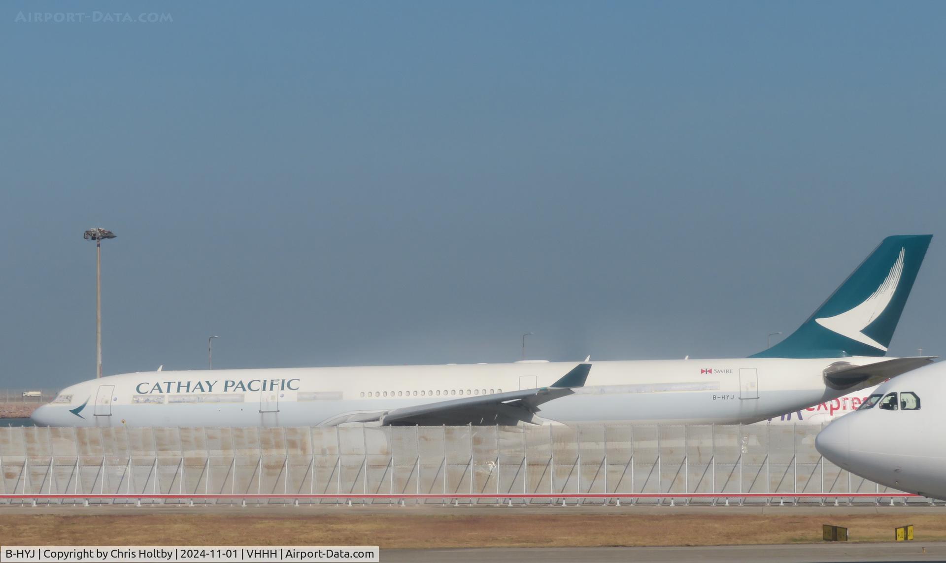 B-HYJ, 2002 Airbus A330-343X C/N 512, Parked & partially covered inside at Hong Kong International in Cathay Pacific livery.