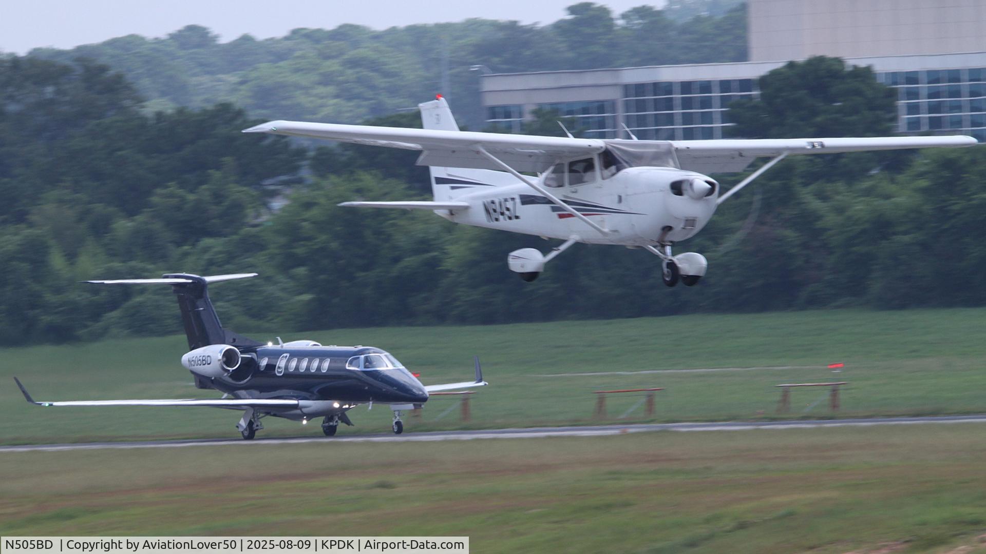 N6867Z, 1981 Cessna 421C Golden Eagle C/N 421C1090, Wheels Up Phenom 300 with Skyhawk landing in foreground