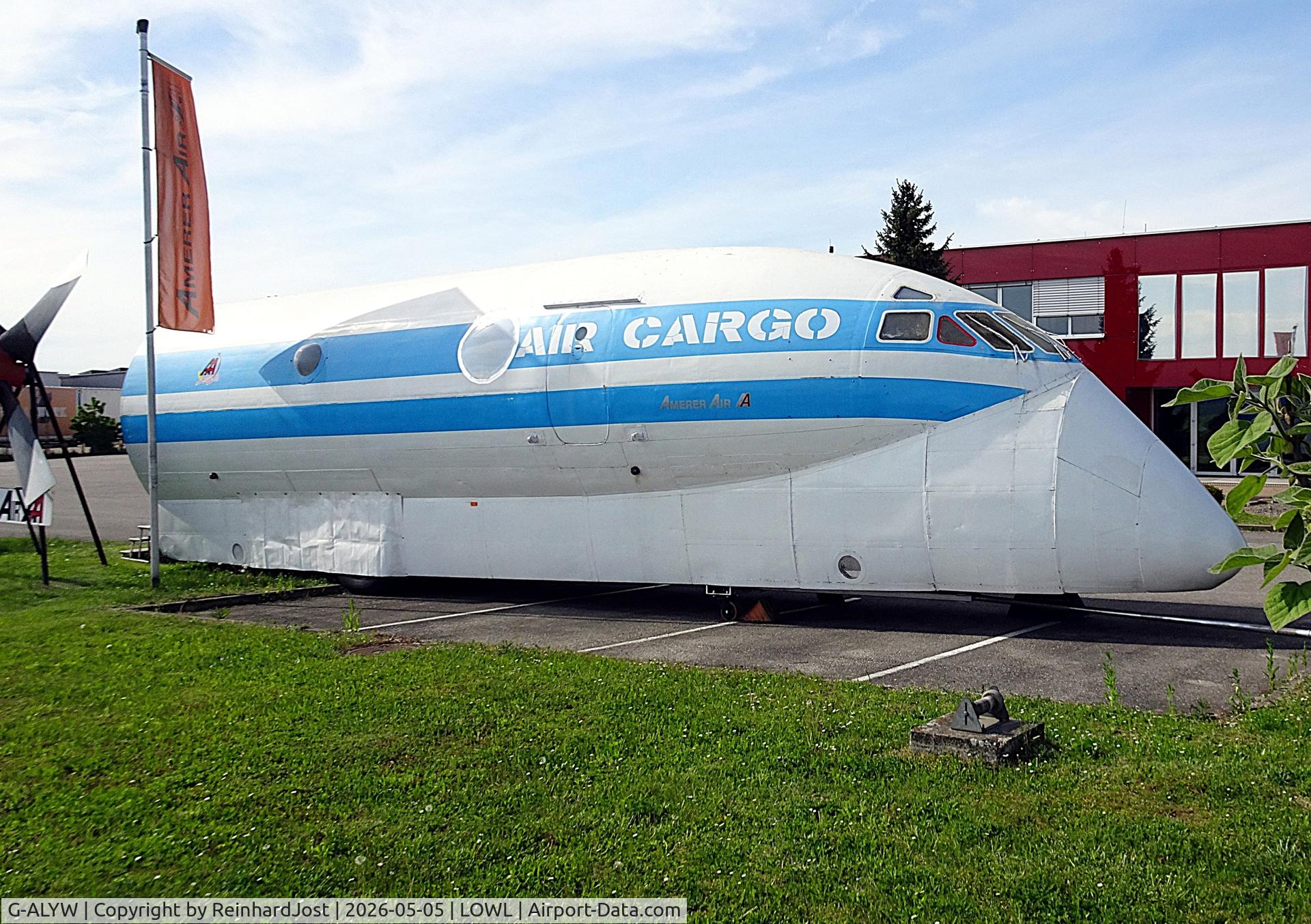 G-ALYW, 1951 De Havilland DH.106 Comet 1, c/n 6009, Comet nose as Nimrod demonstrator with Amerer Air titles in front of the head office of this logistic enterprise at Linz-Hoersching, together with a prop from an L-188 which was used years ago by Amerer Air