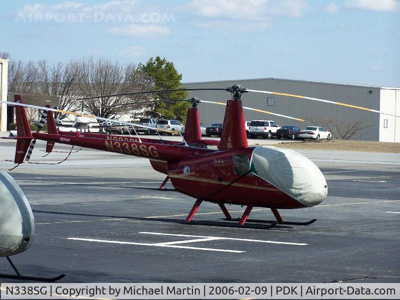 N338SG, 2003 Robinson R44 C/N 1338, Tied down @ PDK with vairous AC in background