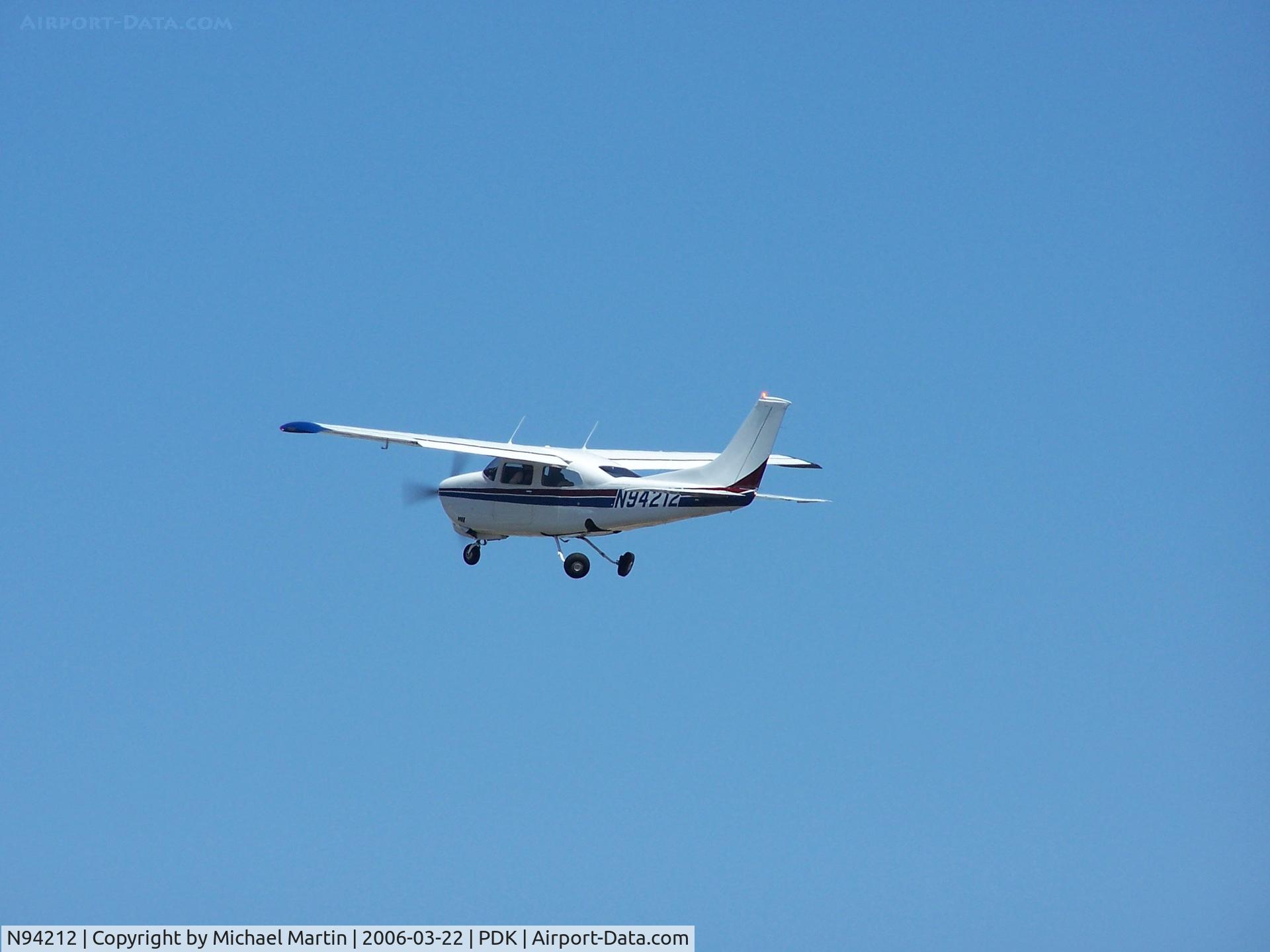 N94212, 1974 Cessna 210L Centurion C/N 21060543, Starting to tuck in gear after departure