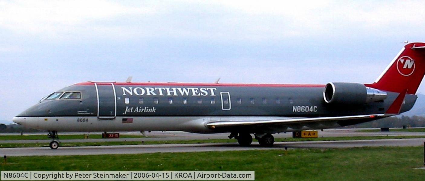 N8604C, 2002 Bombardier CRJ-200 (CL-600-2B19) C/N 7604, Taxiing to the terminal with a departure (just over the tail) in the background