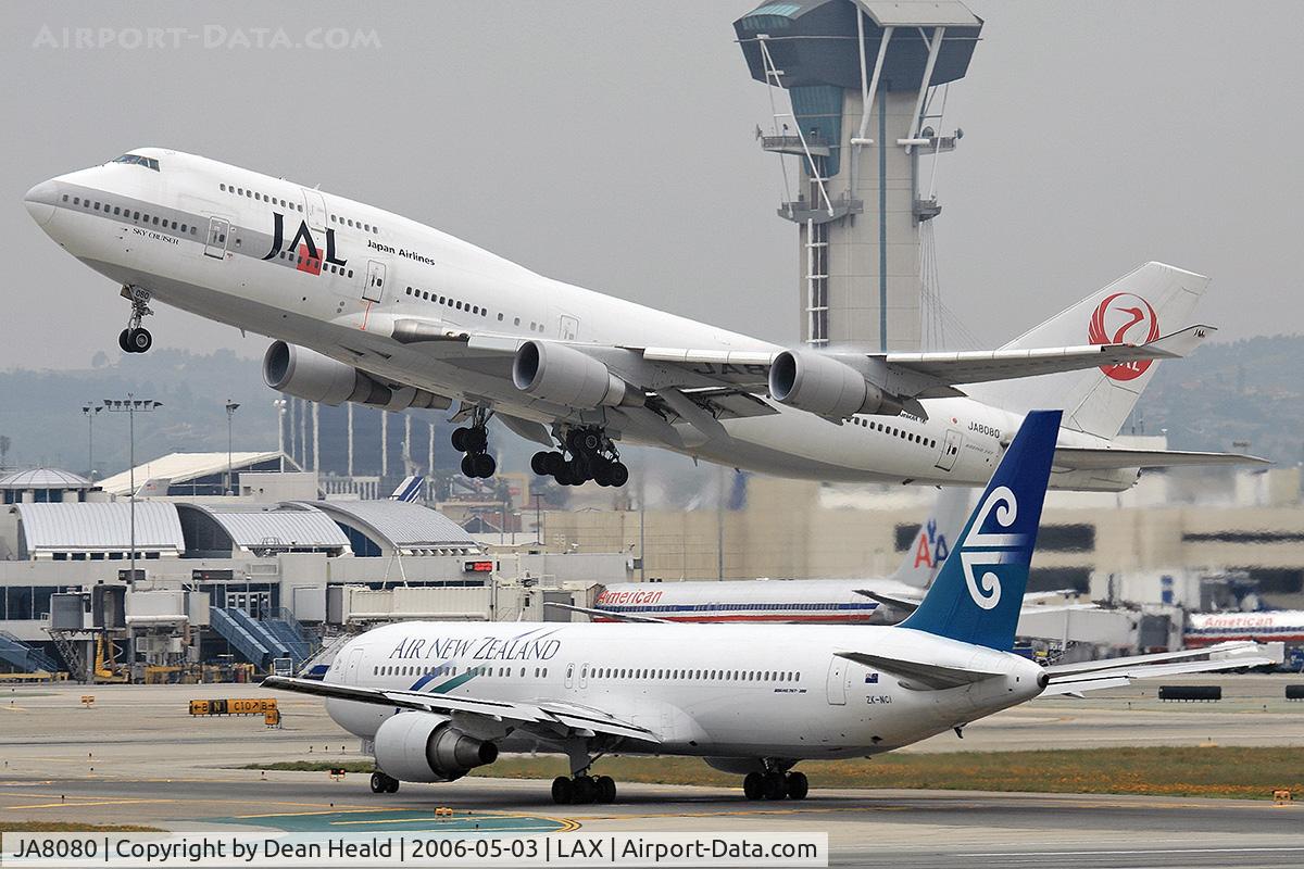 JA8080, 1990 Boeing 747-446 C/N 24886, Japan Airlines JA8080 (FLT JAL61) departing RWY 25R enroute to Narita Int'l (RJAA), Japan.  Air New Zealand ZK-NCI (FLT ANZ22) from Tahiti Faaa (NTAA) is holding short of RWY 25R on Taxiway Papa after arriving on RWY 25L.