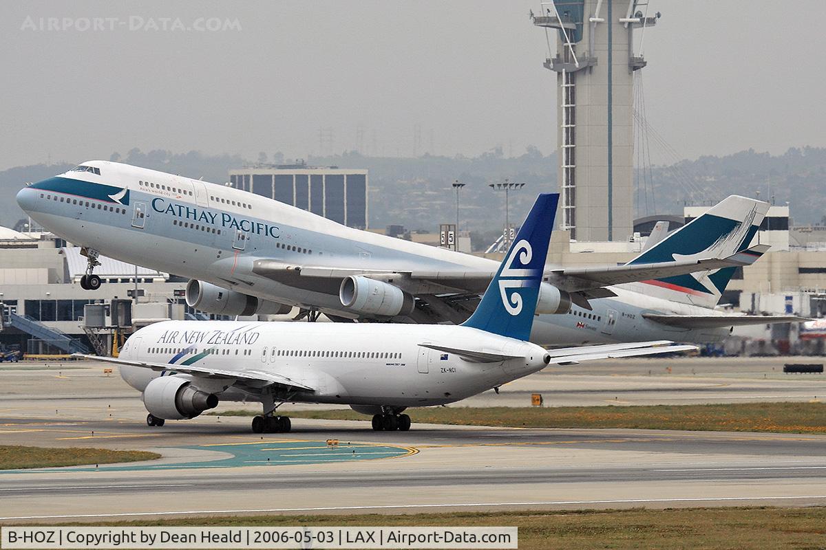 B-HOZ, 1992 Boeing 747-467/BCF C/N 25871, Cathay Pacific B-HOZ (FLT CPA885) departing RWY 25R enroute to Hong Kong Int'l (VHHH), Chna.  Air New Zealand ZK-NCI (FLT ANZ22) from Tahiti Faaa (NTAA) is holding short of RWY 25R on Taxiway Papa after arriving on RWY 25L.