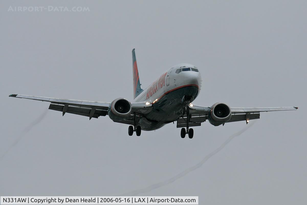 N331AW, 1987 Boeing 737-3Y0/SF C/N 23747, America West N331AW (FLT AWE32) from Phoenix Sky Harbor Int'l (KPHX), with visible condensation trails from the outboard edges of the flaps, on final approach to RWY 24R.