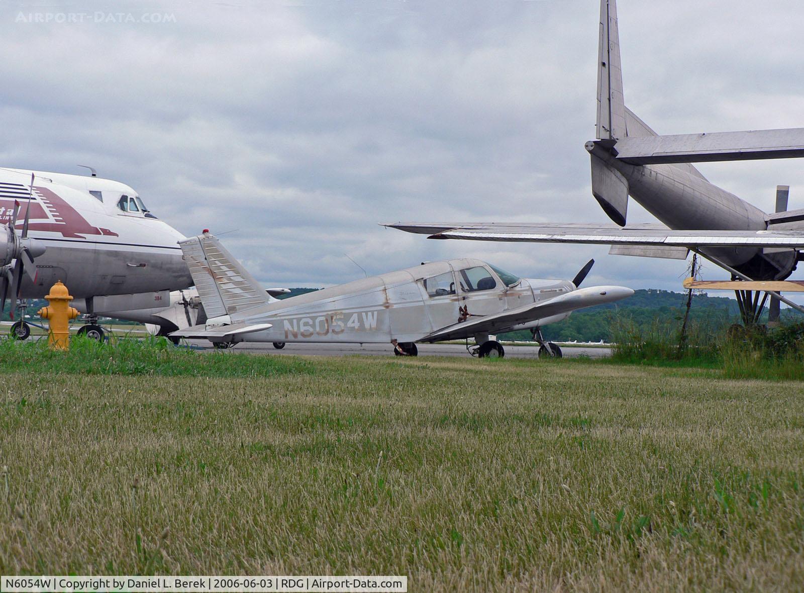 N6054W, 1964 Piper PA-28-140 C/N 28-20066, With a Fairchild C-119, Vickers Viscount 700, Martin 404, and other aeronautical oldies for company, this faded, forlorn 1964 Piper 140 doesn't look it will be going anywhere soon.