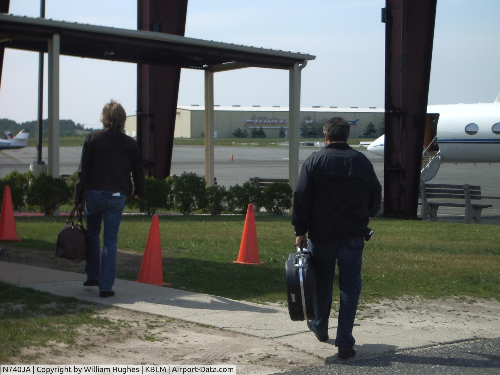N740JA, 1988 Gulfstream Aerospace G-IV C/N 1074, Bon Jovi and his assisant walking to his plane (he was an hour and 30 minutes late)