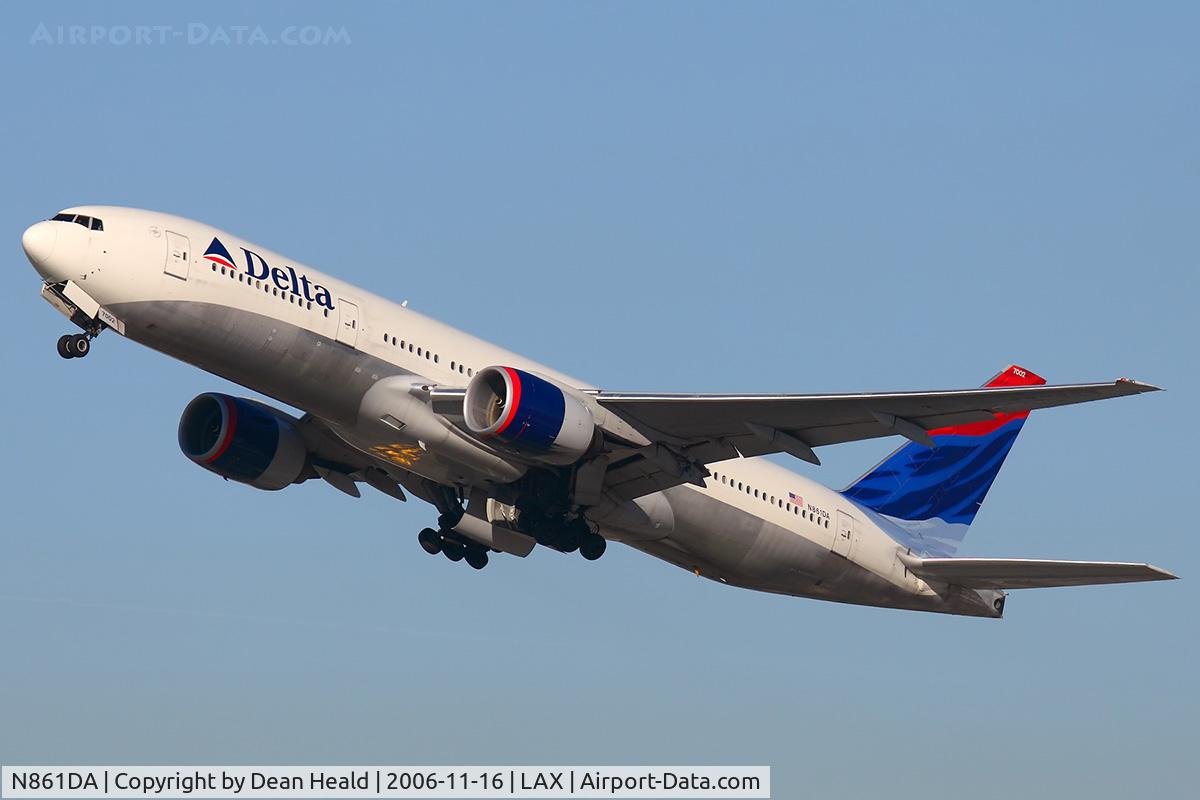 N861DA, 1999 Boeing 777-232 C/N 29952, Delta Airlines N861DA (FLT DAL174) climbing out from RWY 25R. A gold-colored reflection from something on the ground can be seen on the underside of the fuselage.