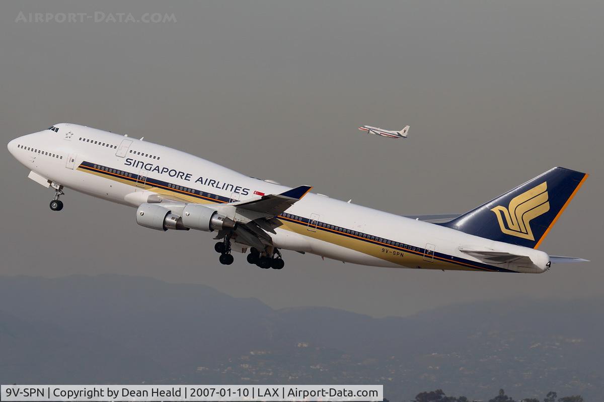 9V-SPN, 2001 Boeing 747-412 C/N 28031, Singapore Airlines 9V-SPN (FLT SIA11) climbing out from RWY 25R on a hazy day enroute to Narita Int'l (RJAA), Japan, with an American Eagle Saab 340 simultaneously climbing out from RWY 24L.