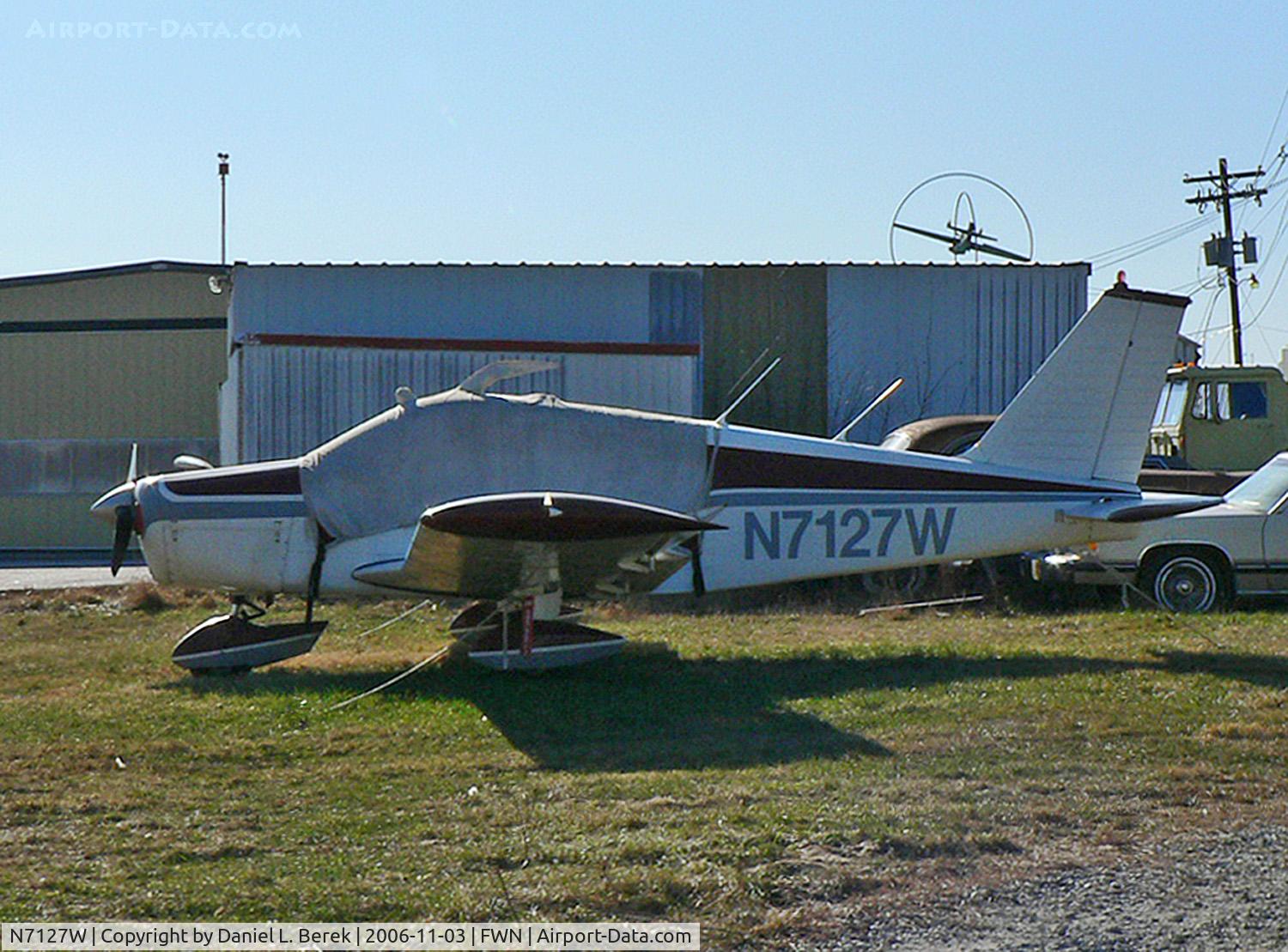 N7127W, 1962 Piper PA-28-180 C/N 28-924, An elderly 1962 Piper Cherokee 180 tries not to have anything to do with the automotive debris in the background.
