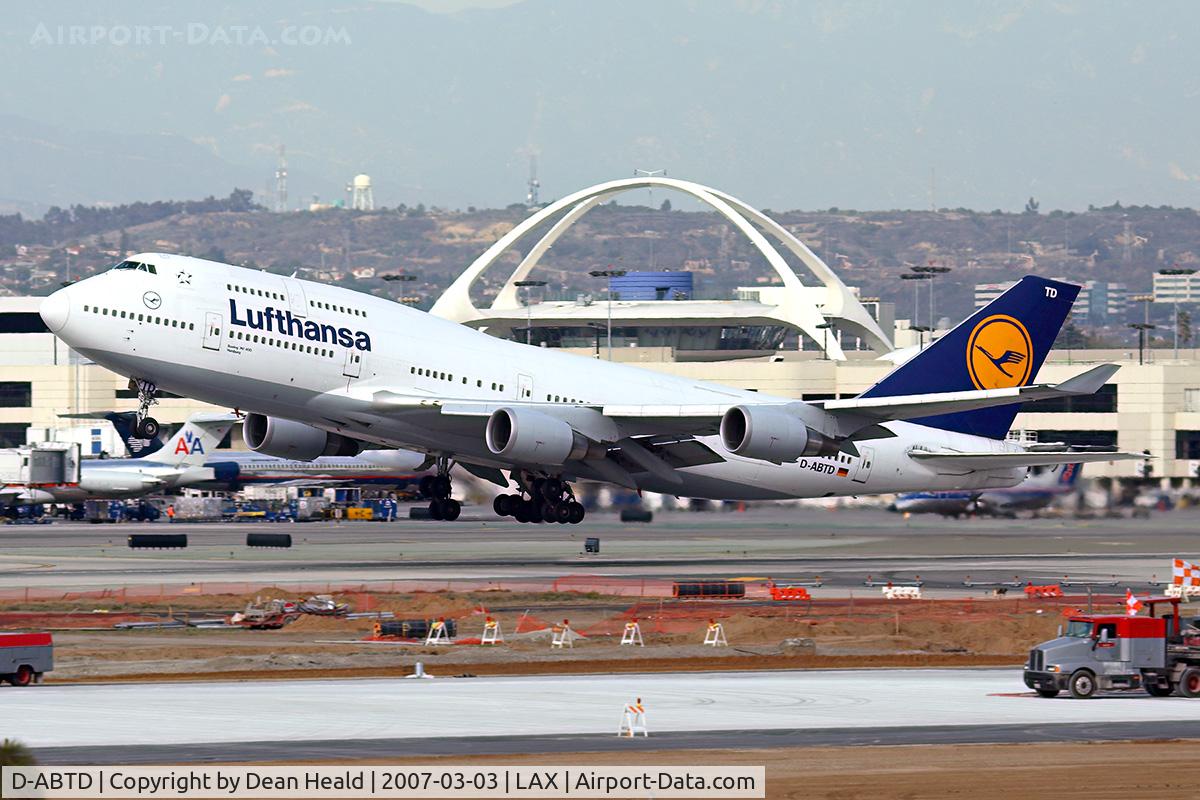 D-ABTD, 1990 Boeing 747-430M C/N 24715, Lufthansa D-ABTD (FLT DLH457) departing RWY 25R, with the LAX landmark Theme building in the background, enroute to Frankfurt Main (EDDF).