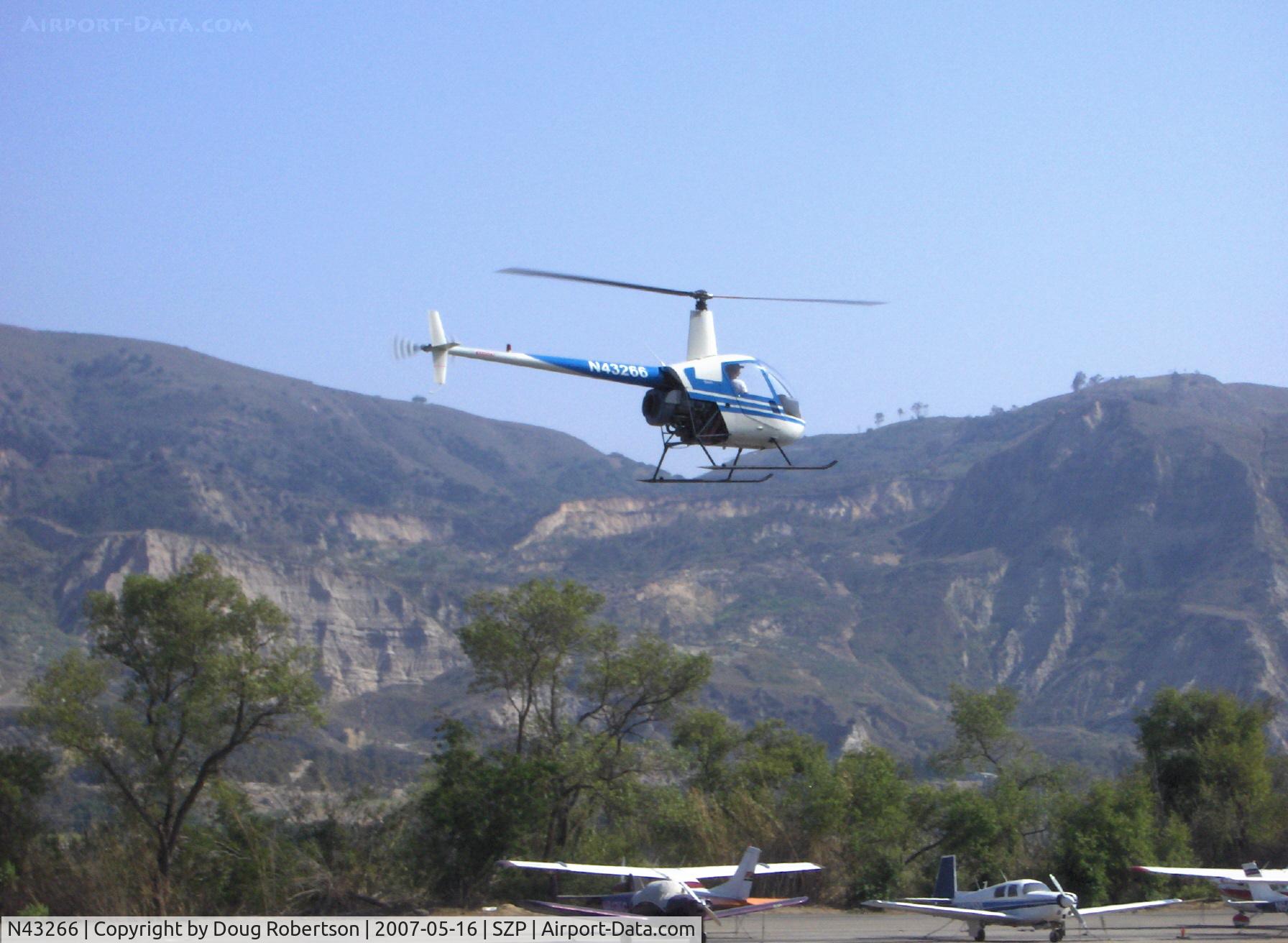 N43266, 1990 Robinson R22 Beta C/N 1268, 1990 Robinson R22 Beta, Lycoming O-320-BC, landing approach to helipad over Rwy 22