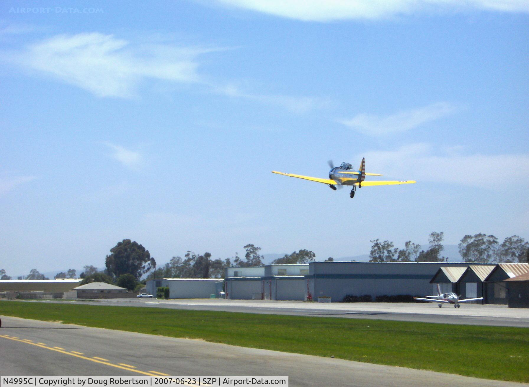 N4995C, 1949 North American T-6G Texan C/N 168-481, 1949 North American T-6G TEXAN 'Thirsty Girl', P&W R-1340 600 Hp, gear coming up. N110AM Moravan Zlin Z242L on taxiway.