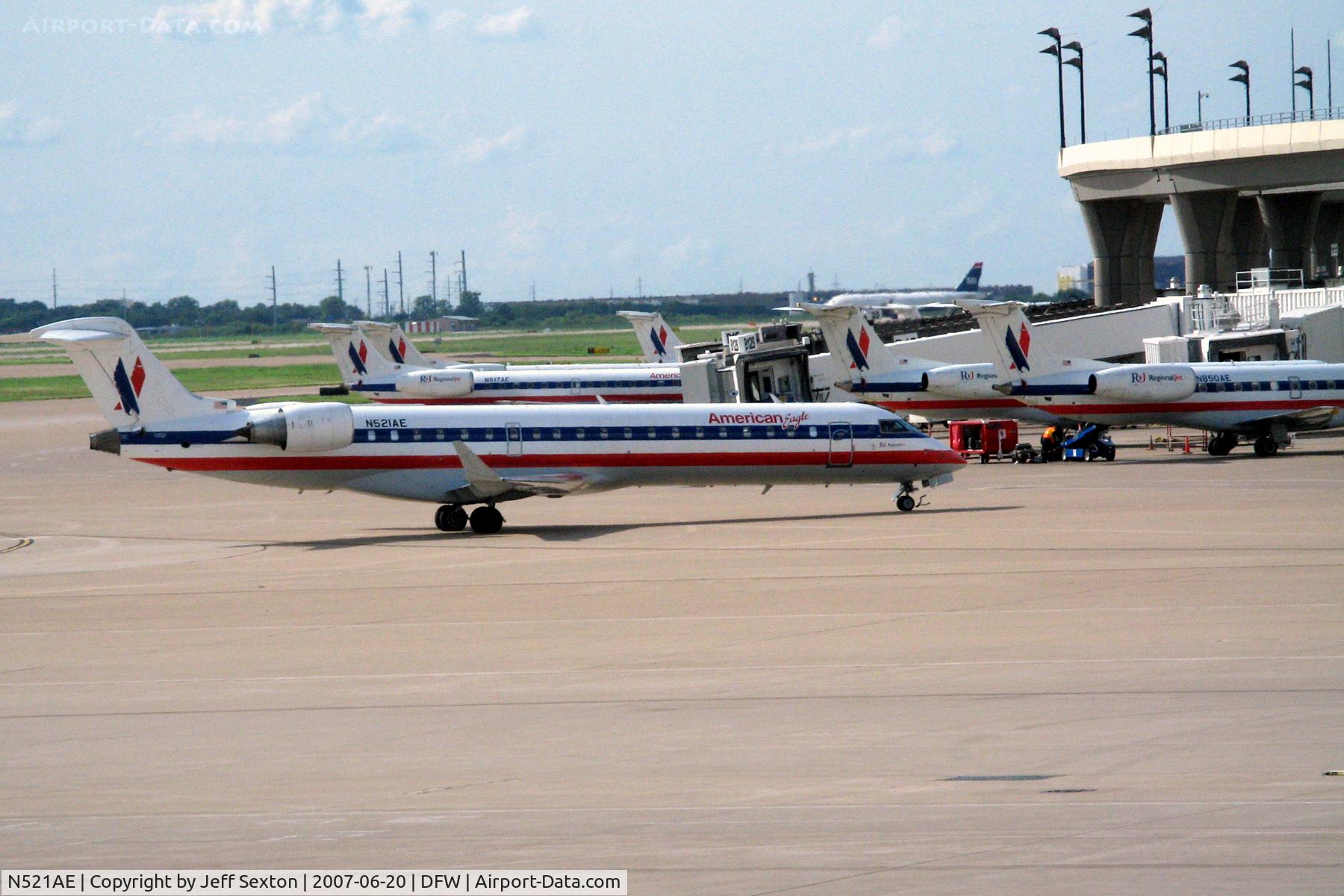 N521AE, 2004 Bombardier CRJ-701 (CL-600-2C10) Regional Jet C/N 10142, American Eagle N521AE taxiing in with Embraer a/c N617AE, N850AE and others in the background.