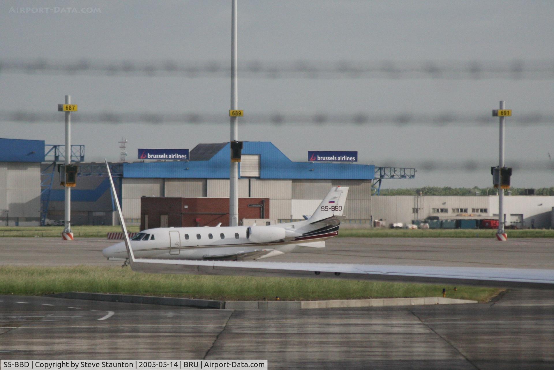 S5-BBD, 2000 Cessna 560 Citation Excel C/N 560-5058, Taken from inside a coach at Brussels Airport