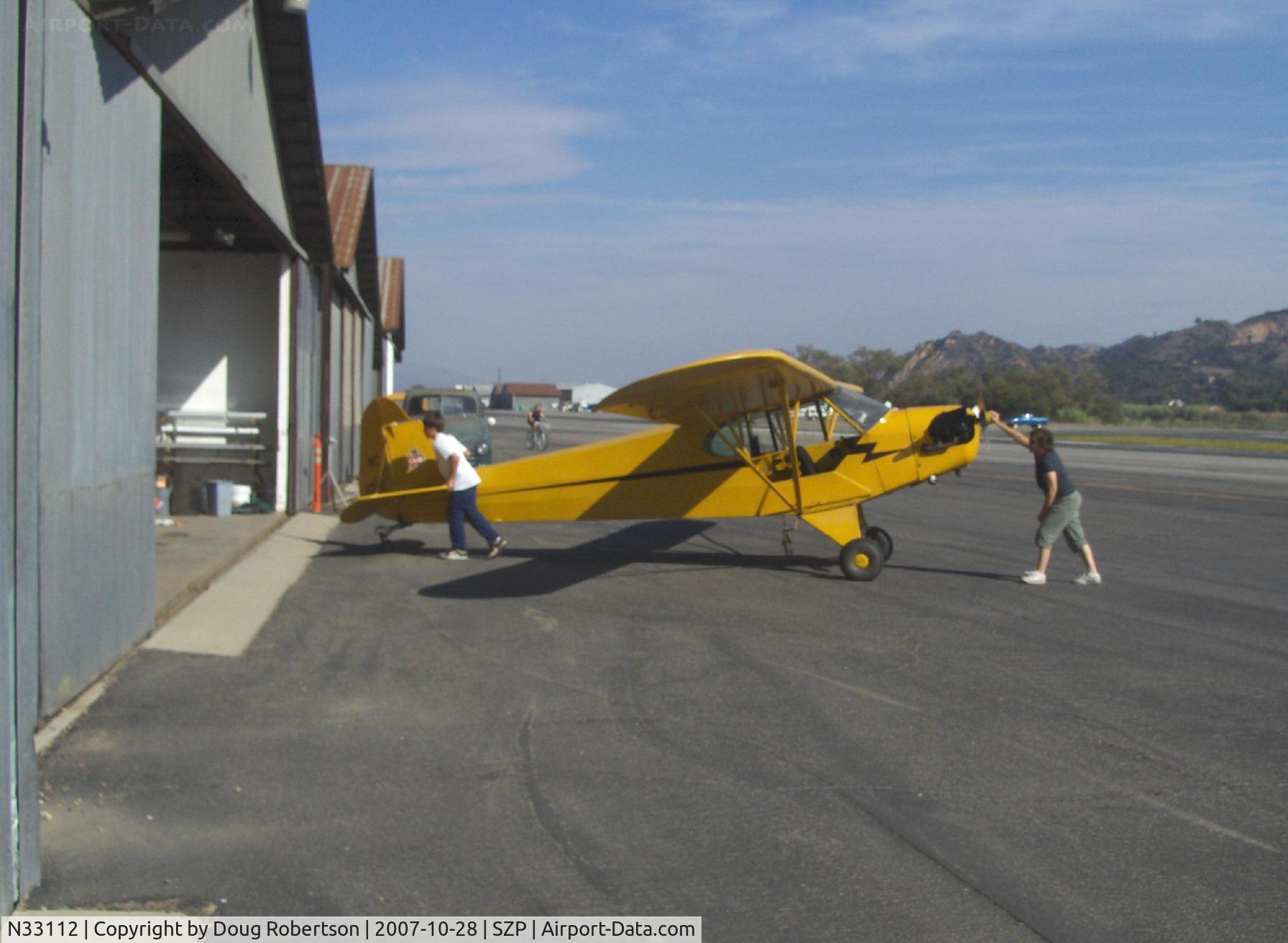 N33112, 1940 Piper J3C-65 Cub Cub C/N 5830, 1940 Piper J3C-65 CUB, Continental C90 90 Hp upgrade, Mom & son returning from a flight-pushing plane back in hangar