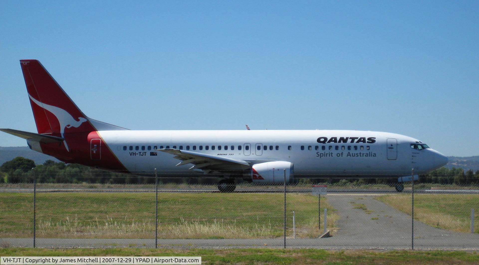 VH-TJT, 1993 Boeing 737-476 C/N 24445, Taxing F6, For Rwy 05. On a nice 'hot' 38 degree C. day! (Not a cloud in the sky) Shame about the fence though =(