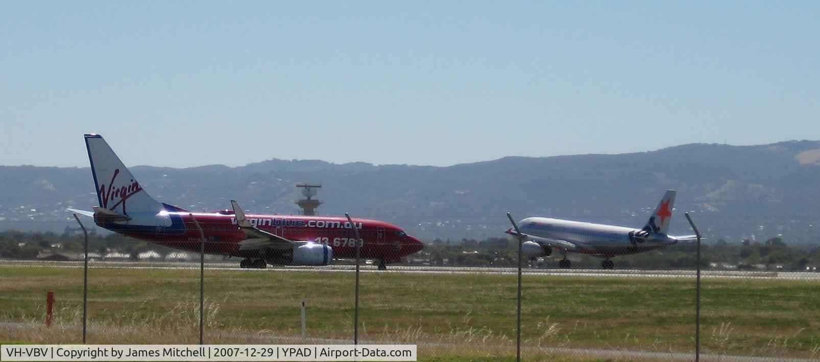 VH-VBV, 2003 Boeing 737-7BK C/N 33015, Taxiing F5, For Rwy 05. Nice with the Jetstar A320-200 in the background! Too bad about the fence though =(