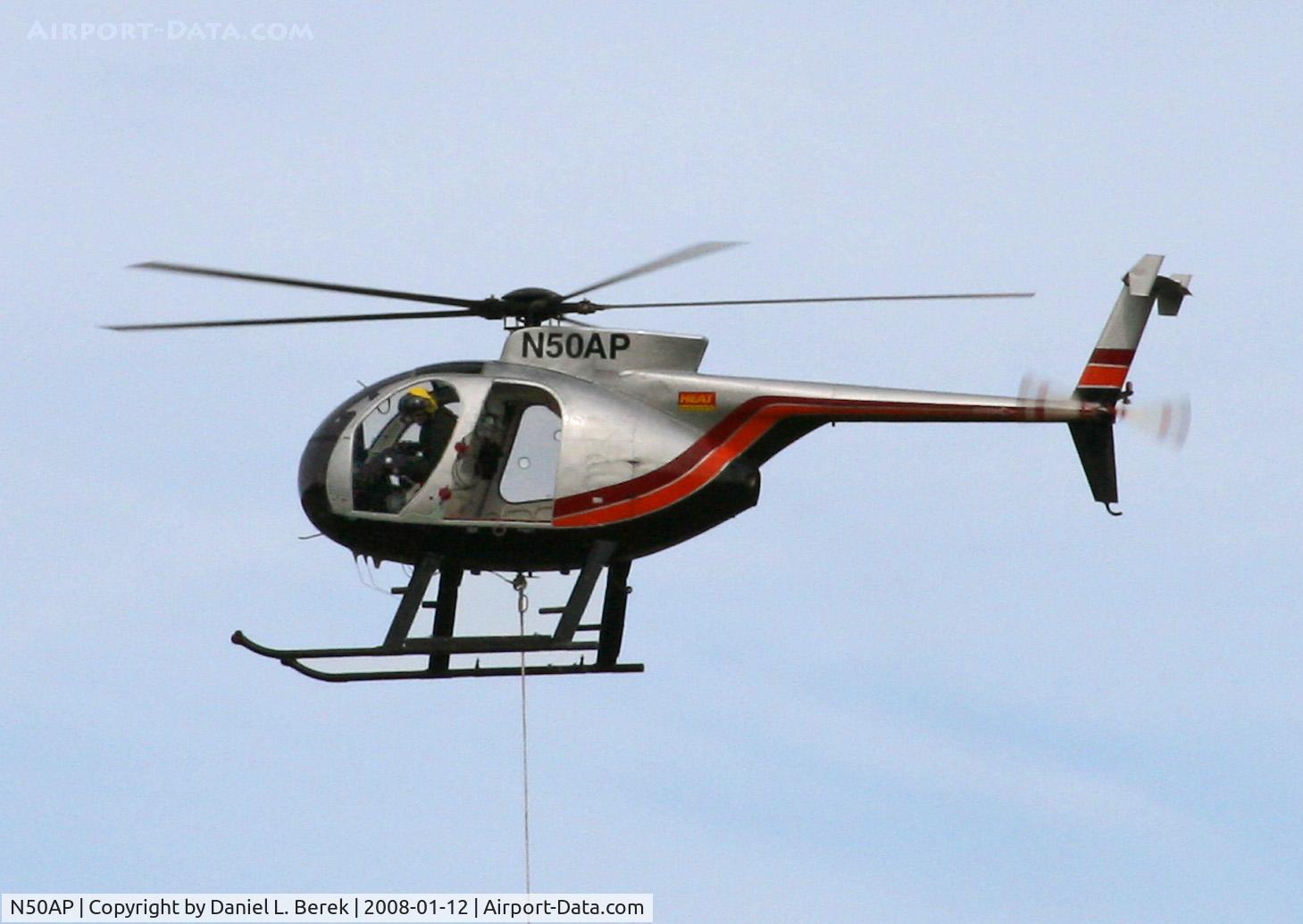 N50AP, 1979 Hughes 369D C/N 1090585D, Easy does it!  The pilot is gingerly maneuvering a component for a powerline into place.