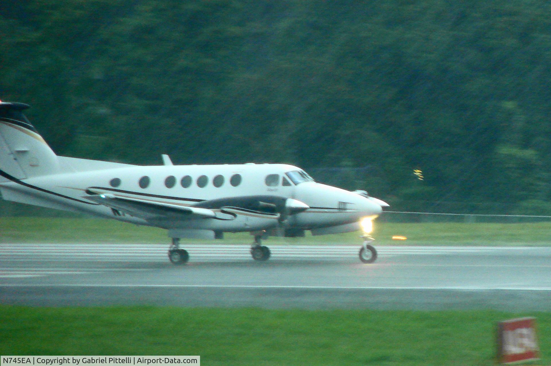 N745EA, 2001 Raytheon Aircraft Company B200 C/N BB-1745, Wal MartÂ´s Beech B200 N745EA taking off  under heavy rain at MROC