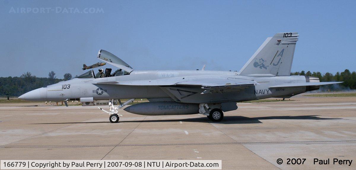 166779, 2006 Boeing F/A-18E Super Hornet C/N E125, As she comes in, the Strikemaster is taking off (see canopy)