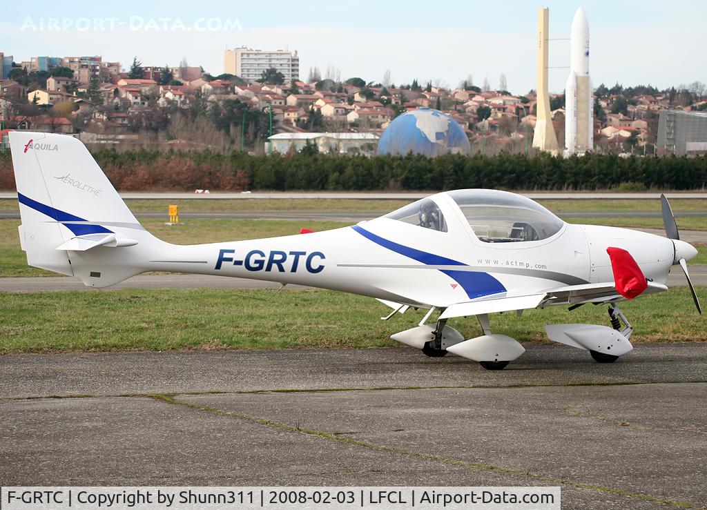 F-GRTC, Aquila A210 (AT01) C/N AT01-111, Parked in front of the Airclub and with Space City in the background