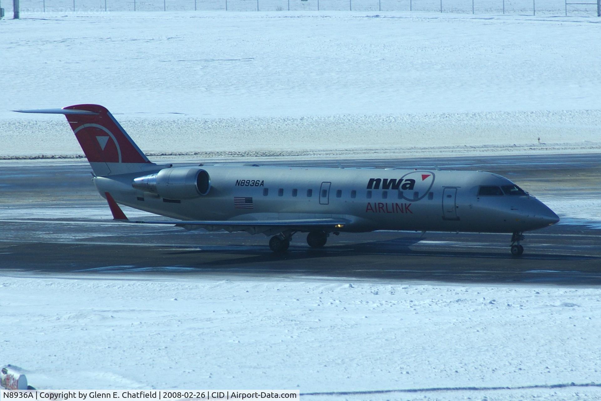 N8936A, 2004 Bombardier CRJ-200 (CL-600-2B19) C/N 7936, Departing Runway 31.  Not good lighting - shooting into the sun with blowing snow