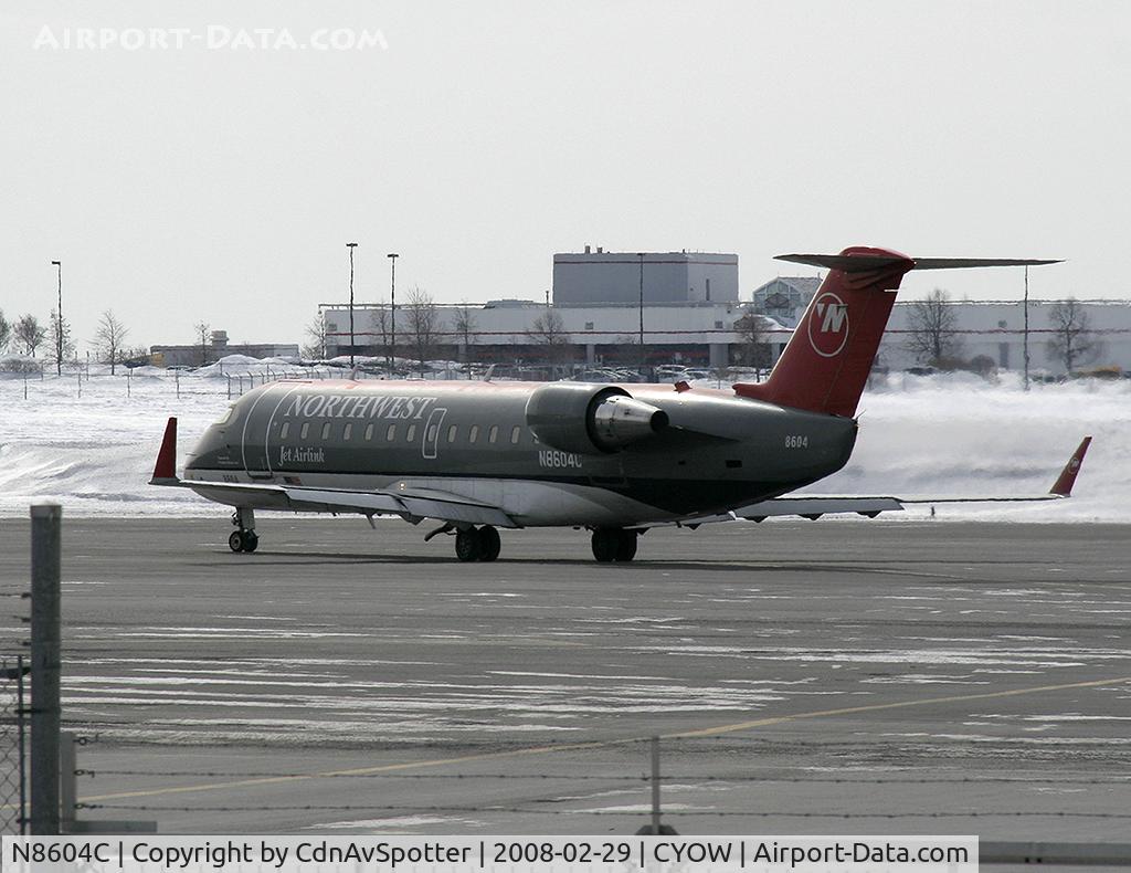 N8604C, 2002 Bombardier CRJ-200 (CL-600-2B19) C/N 7604, NW CRJ leaving the US Departures area, and taxiing to Rwy 32