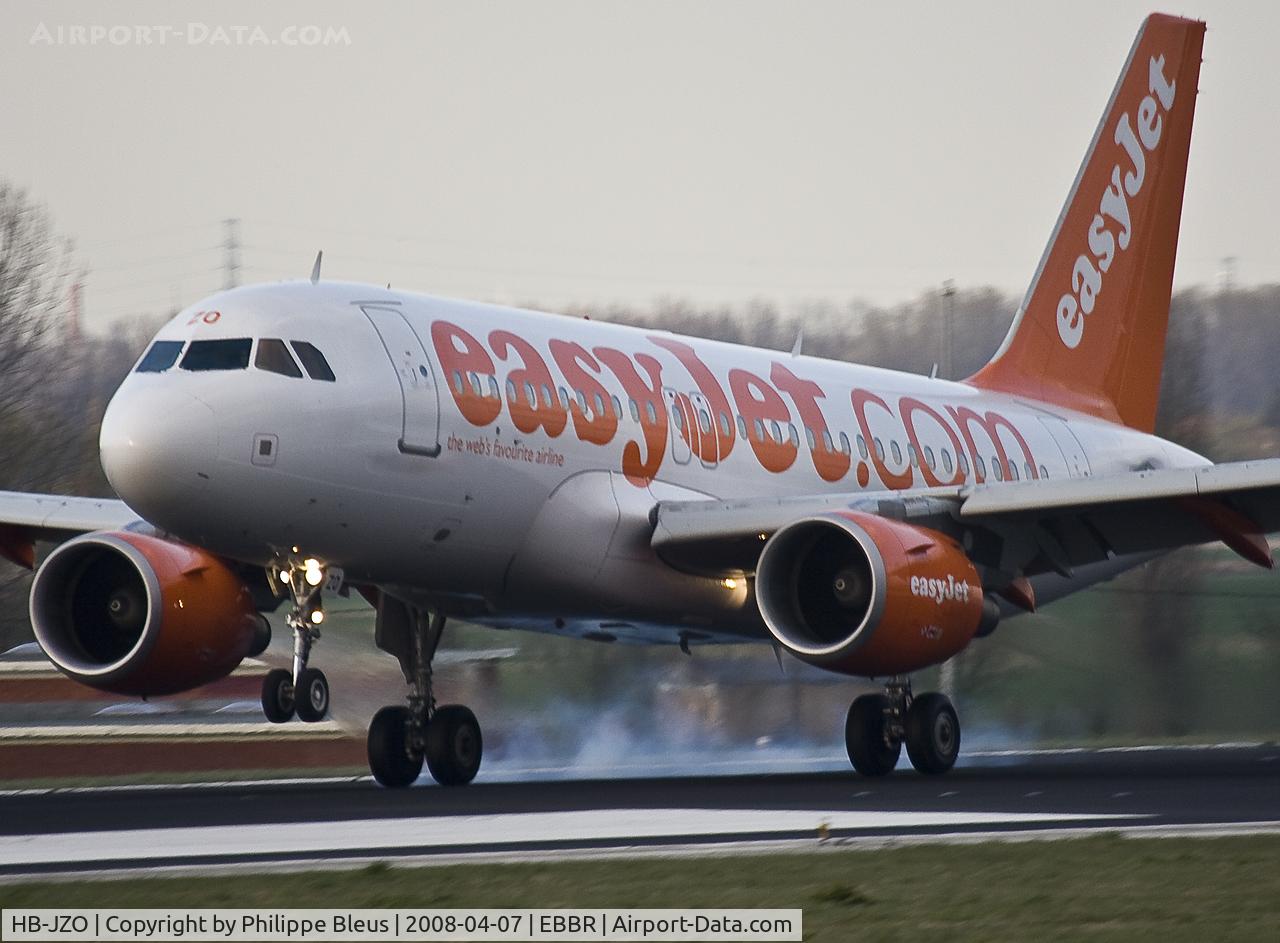 HB-JZO, 2005 Airbus A319-111 C/N 2398, Swiss EasyJet with (as usual TWO central emergency exit doors) burning rubber on rwy 25L at sunset.