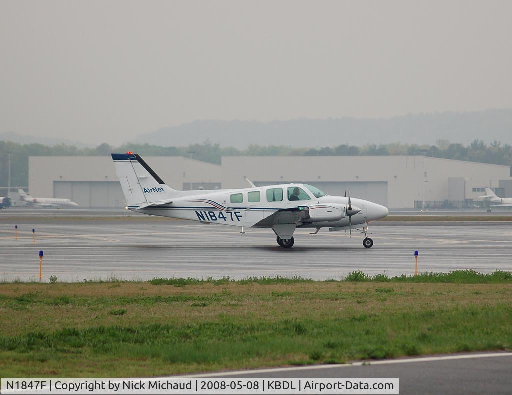 N1847F, 1981 Beech 58 Baron C/N TH-1291, Airnet pulling into thr Tac Air ramp during some morning showers