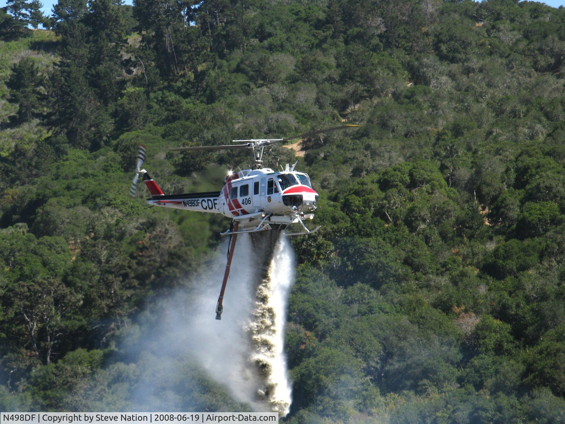 N498DF, Bell UH-1H C/N 69-15865, CDF Bell UH-1H Helitak 406 dropping on fire off of State Hwy 68 ~ 4 miles NE of Monterey, CA