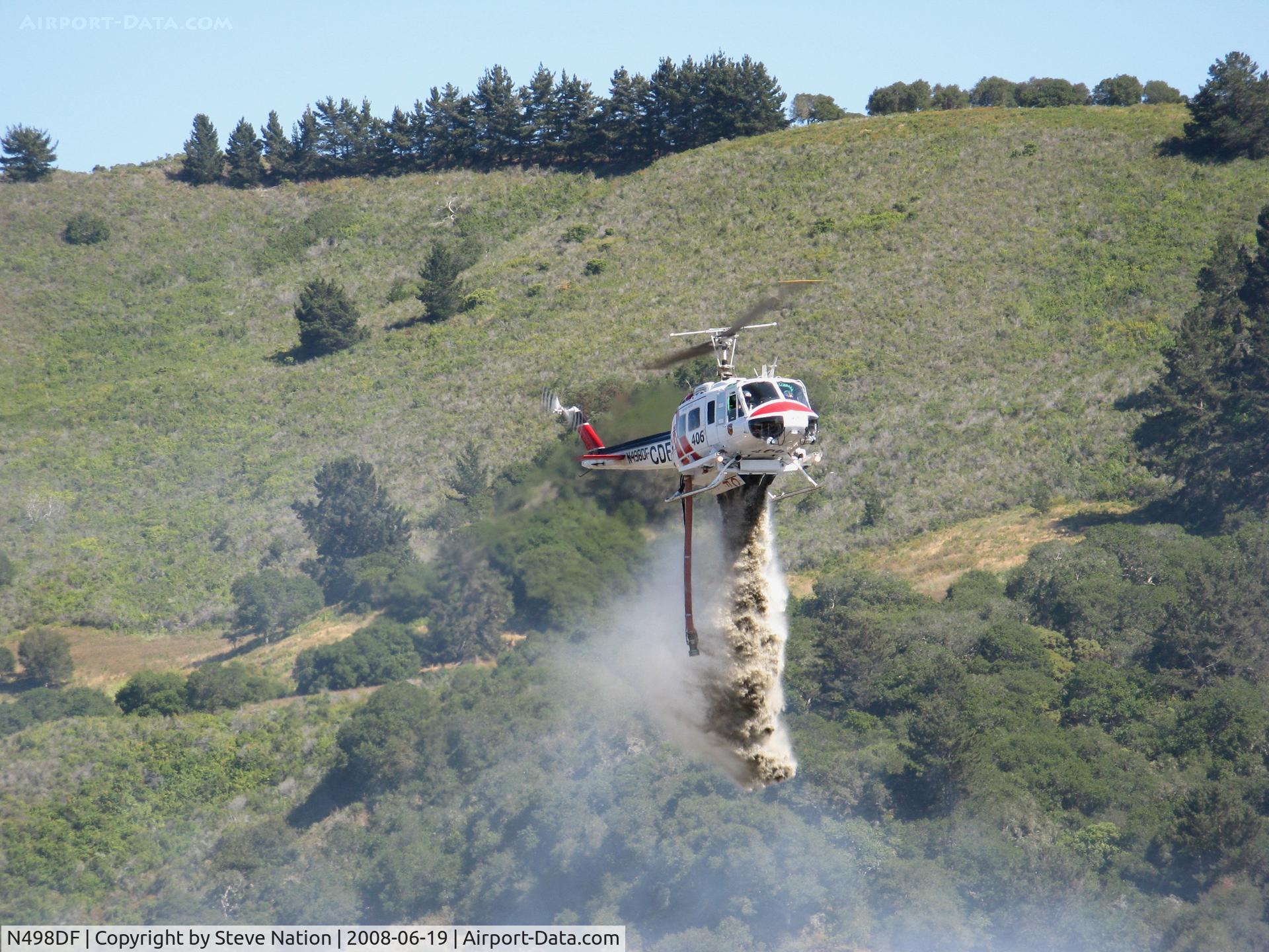N498DF, Bell UH-1H C/N 69-15865, CDF Bell UH-1H Helitak 406 dropping on fire off of State Hwy 68 ~ 4 miles NE of Monterey, CA