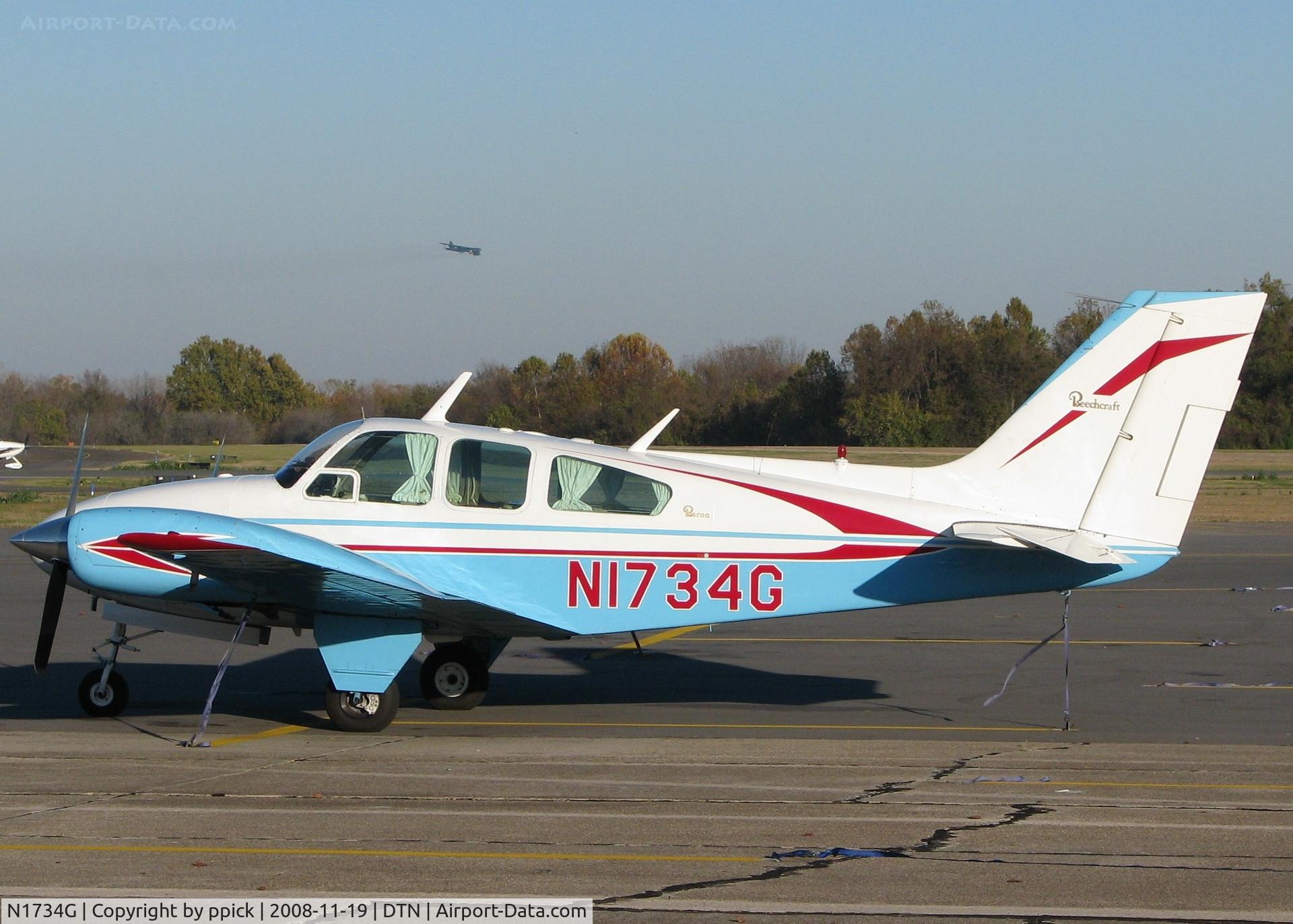 N1734G, 1962 Beech 95-A55 Baron C/N TC-275, Parked at Downtown Shreveport with a B-52 from Barksdale Air Force Base in the background.