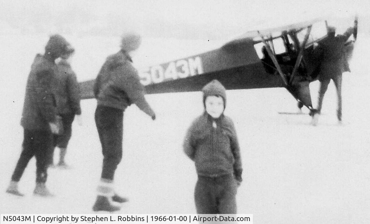 N5043M, 1946 Taylorcraft BC-12D-85 Sportsman C/N 10343, Gerald Robbins turning propeller, on the ice at China Lake, East Vassalboro, Maine in January 1966.