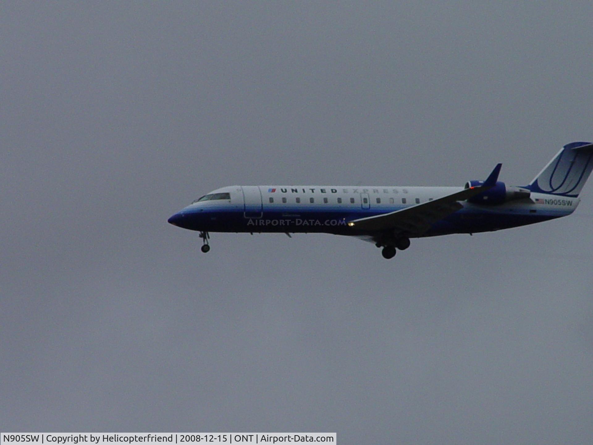 N905SW, 2000 Bombardier CRJ-200LR (CL-600-2B19) C/N 7437, Almost over the fence and landing in the rain at Ontario